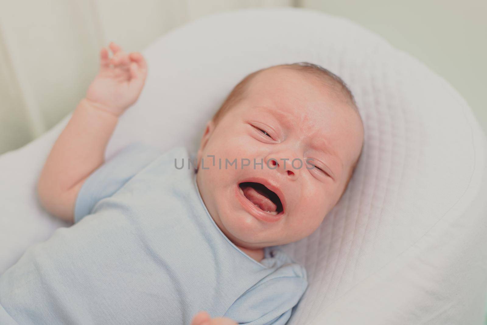 A hungry baby is crying in the crib . Baby crying. Children 's emotions . Pain during teething. A hungry child. Children's colic in the stomach. Lifestyle