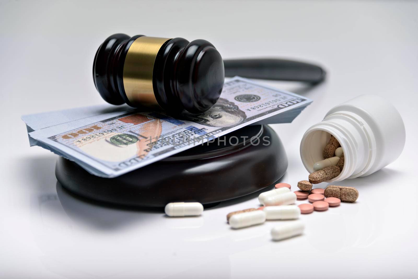 Medicine law concept. Gavel, stethoscope and pills isolated on white