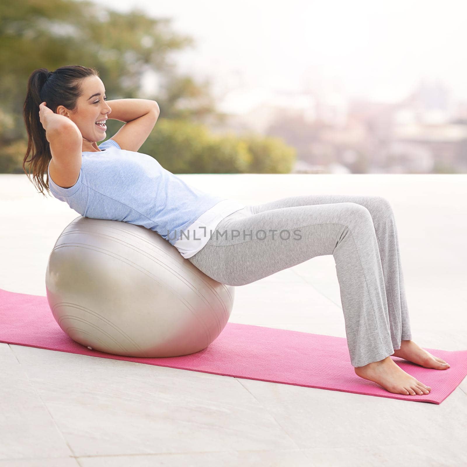 Ready for some ball work. Full length shot of a young woman doing yoga outdoors