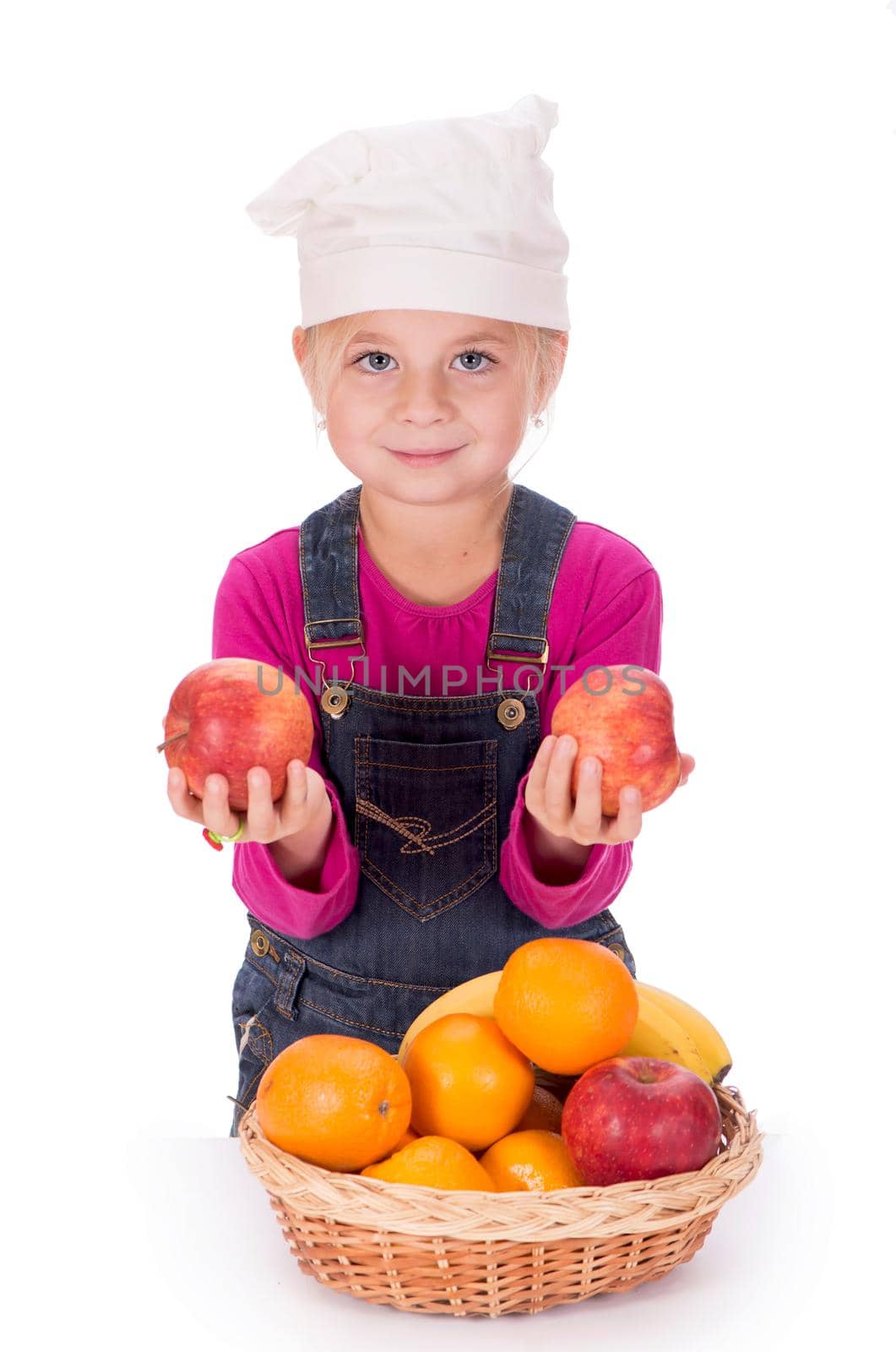 Close-up portrait of a little girl holding fruits - apples, bananas and oranges. Isolated on a light background. by aprilphoto