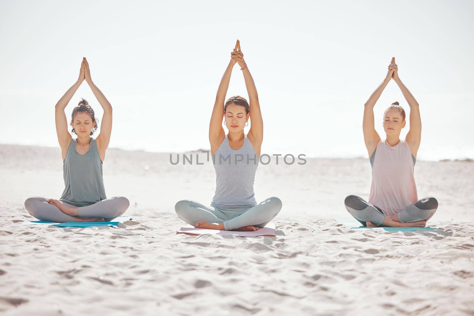 Beach yoga, fitness women and meditation, stretching and balance in lotus pose on sandy seashore. Praying exercise, peace and healthy workout for energy, mind wellness and zen training in calm focus.