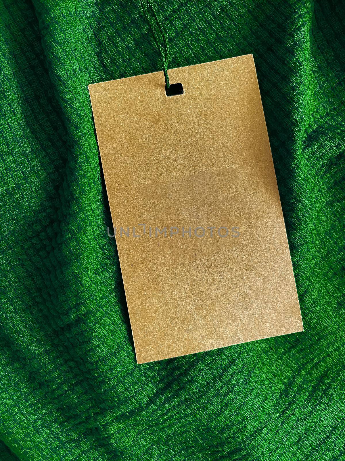 Blank fashion label tag, sale price card on luxury fabric background, shopping and retail concept