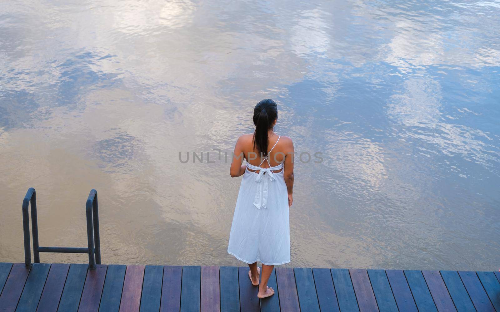 Asian women standing at water front by the river by fokkebok