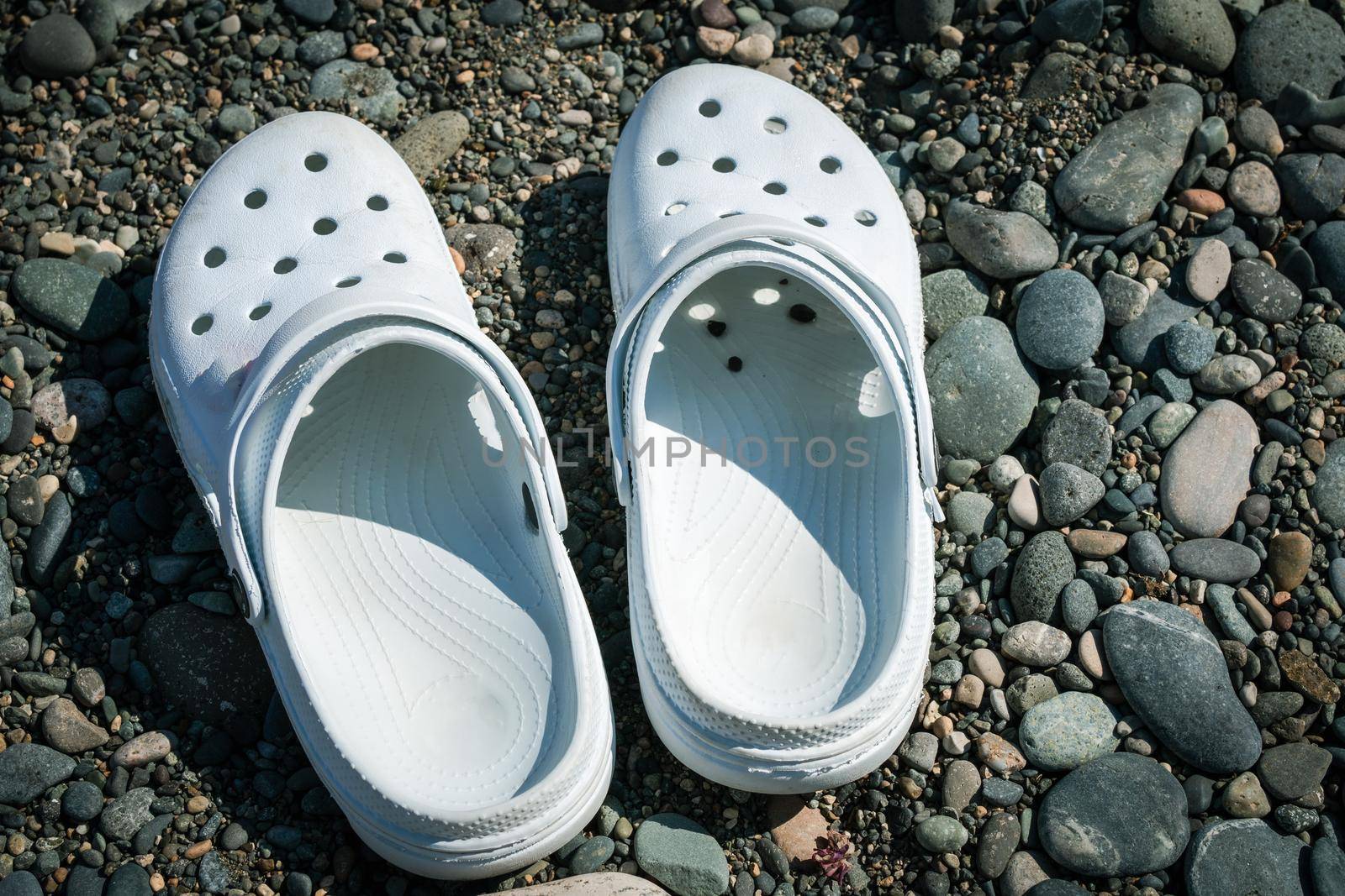 Rubber slippers on the background of stones on the beach.
