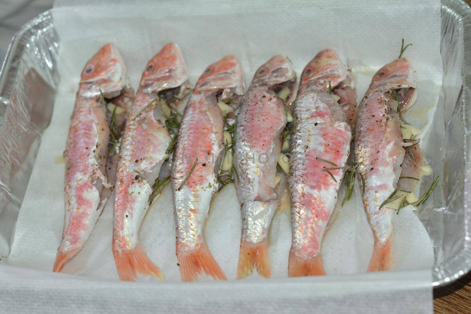 Preparation mullet with rosemary and garlic for baking in the oven