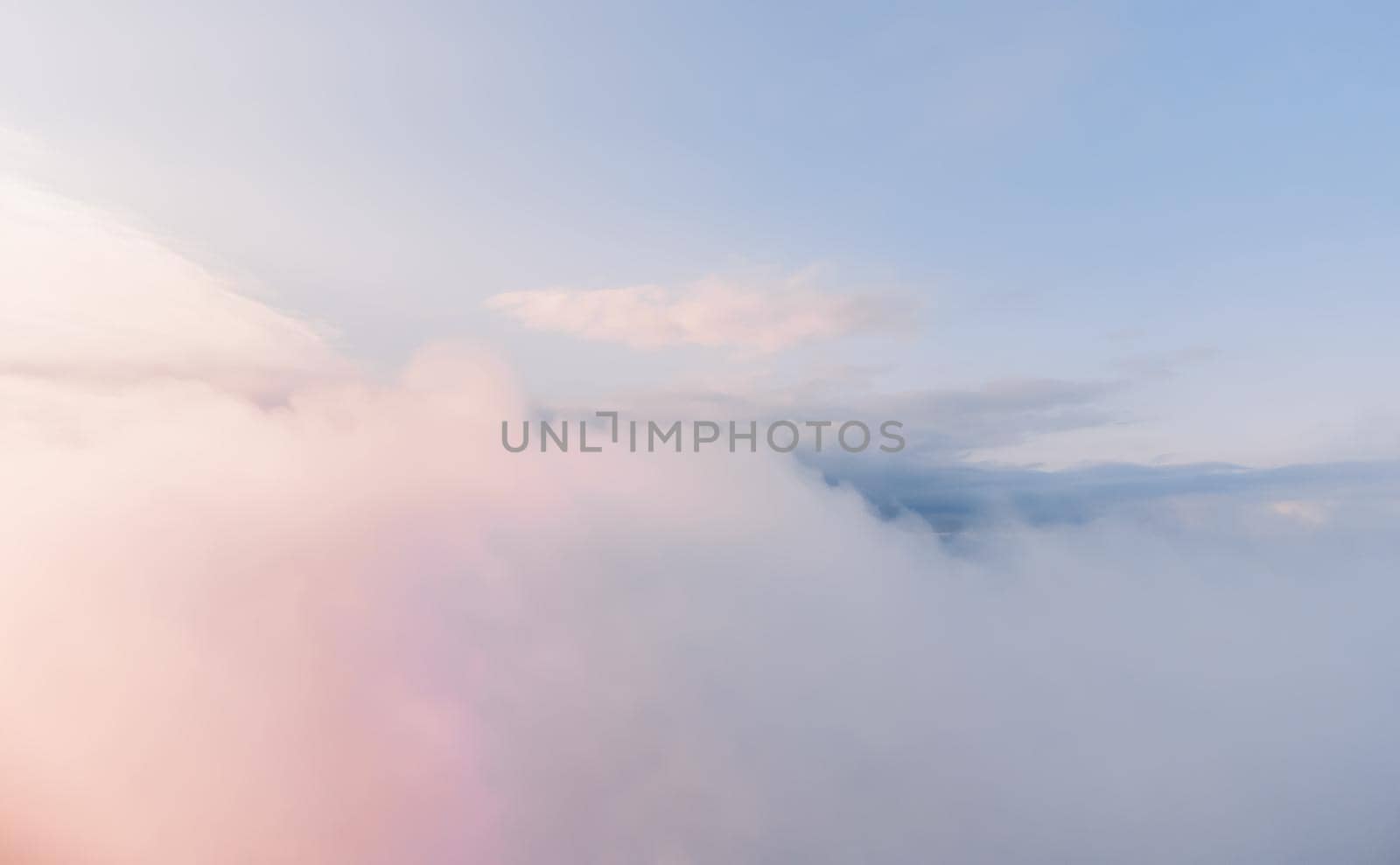 Aerial view. The drone flies over foggy and fluffy clouds. Blue sky sun and sea fog. Abstract aerial nature summer ocean sunset sea and sky background. Vacation, travel and holiday concept by panophotograph