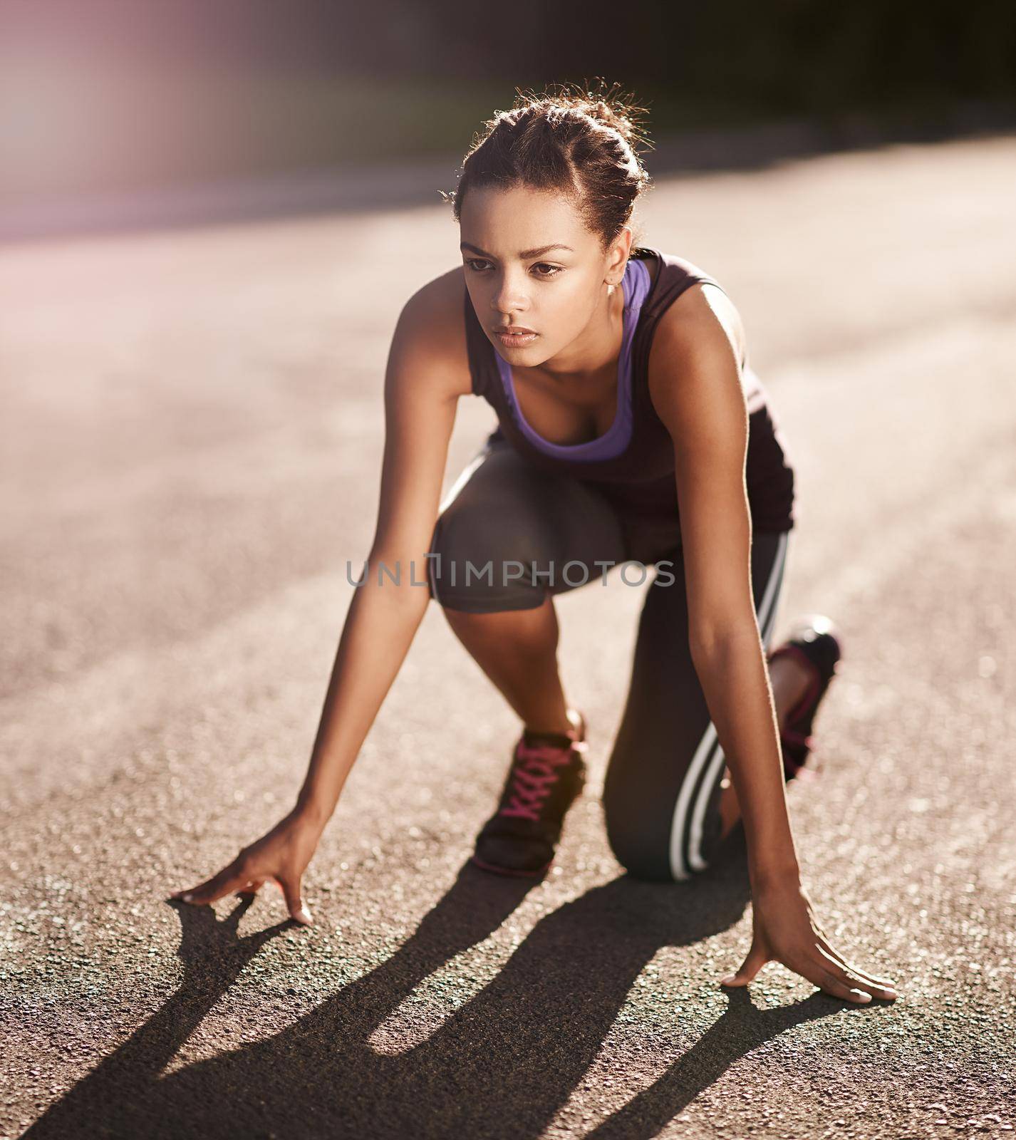 Fitness is a lifestyle with no finish line. a young woman in the starting position for a run