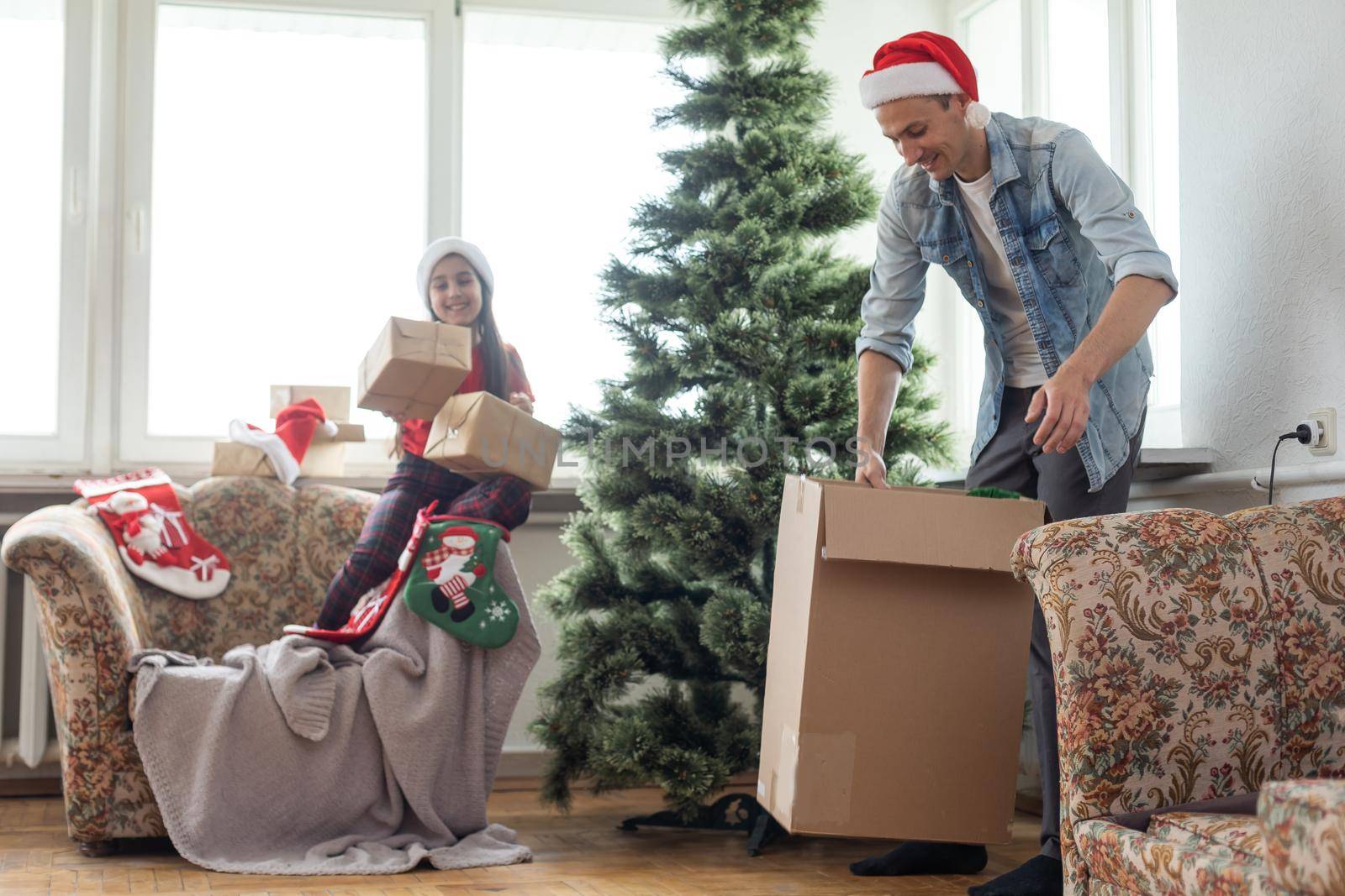 Happy father and young daughter decorate the Christmas tree at home, morning before Xmas, Merry Christmas and Happy Holiday Concept