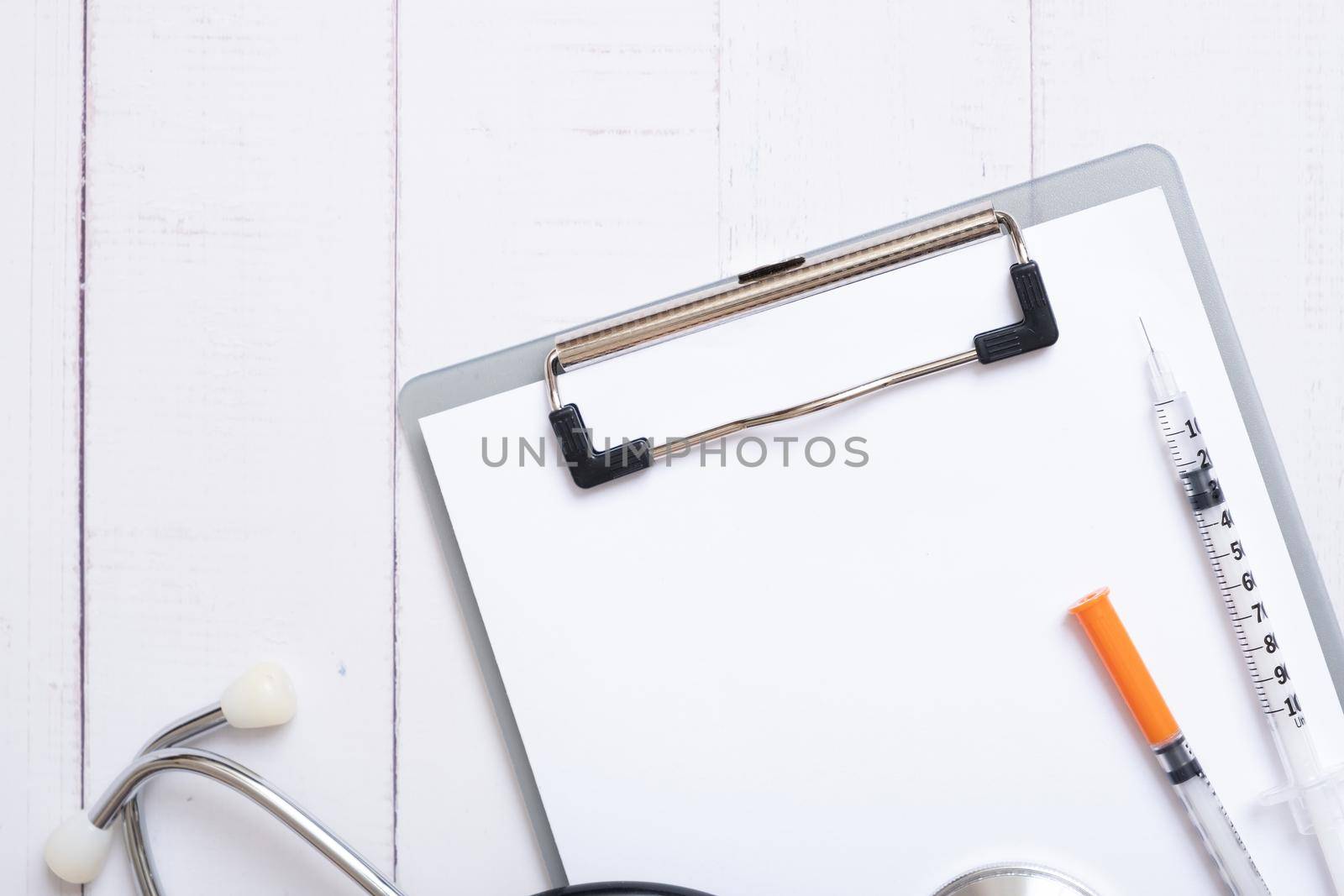 Syringes and stethoscope with blank tablet on wooden background top view. Treatment of diabetes concept.