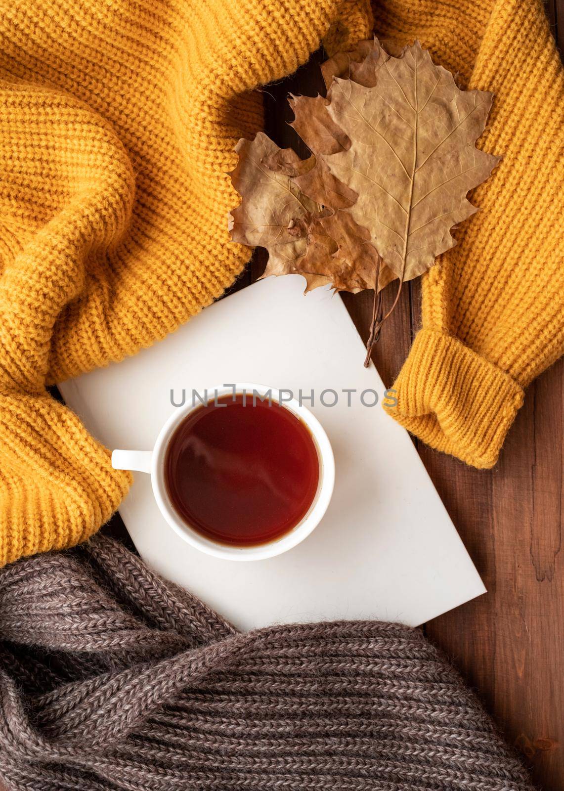 Cozy autumn composition, sweater weather. Tellow leaves, hot tea and sweaters by Desperada