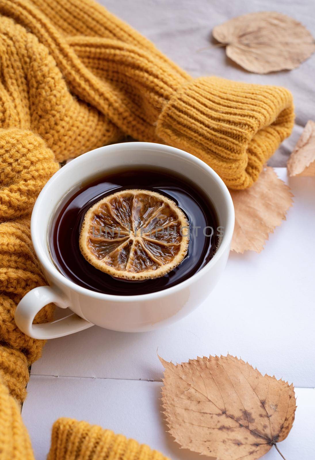 Cozy autumn composition, sweater weather. Pumpkins, hot tea and sweaters on window by Desperada