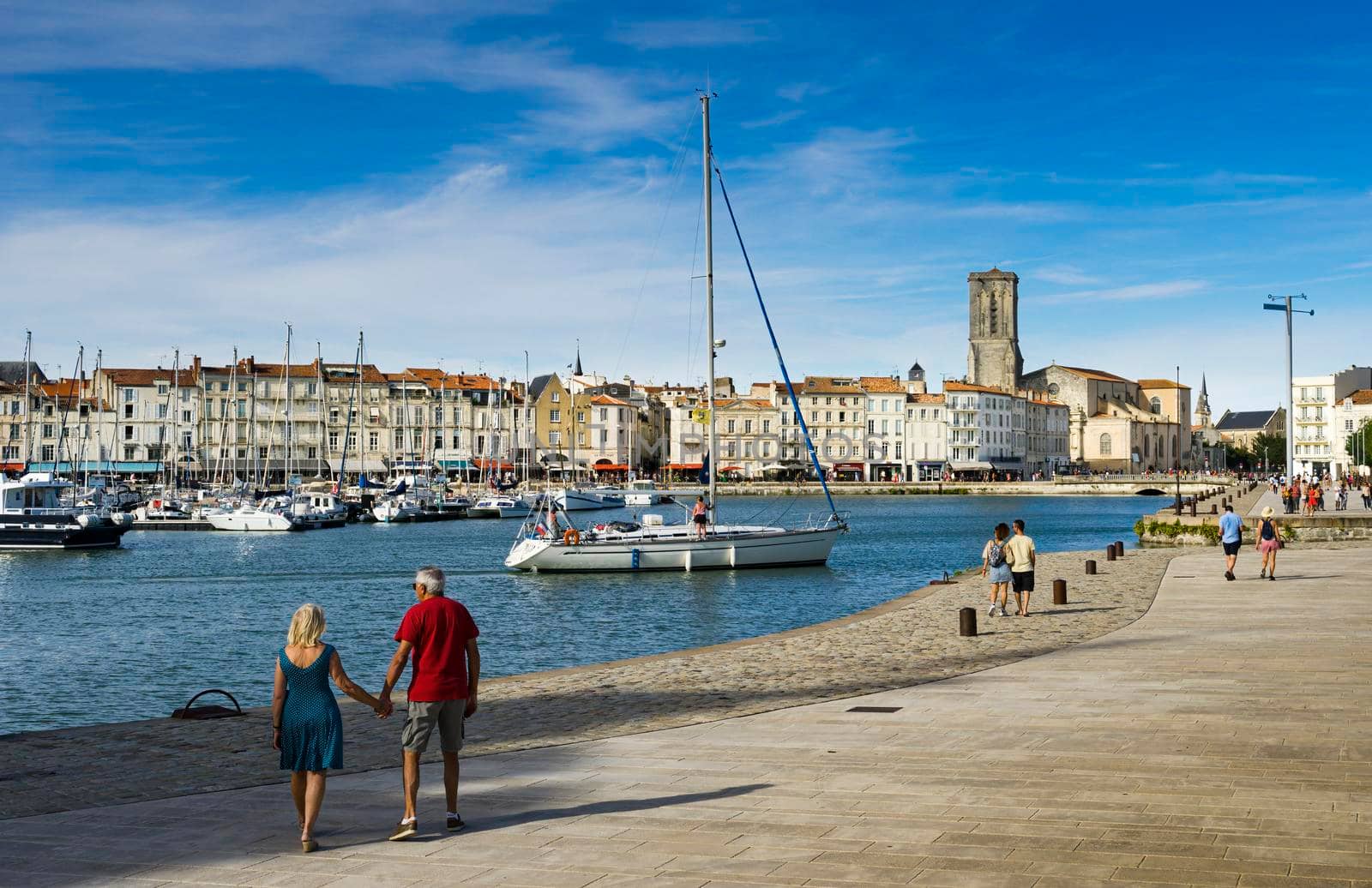 View of the old harbour of the French city of La Rochelle with tourists strolling. by csbphoto