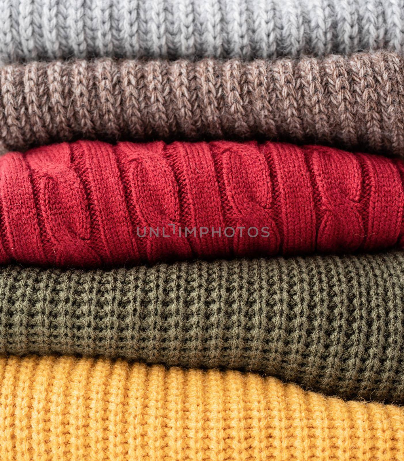 Hello fall. Cozy warm image. Stack of colorful autumn warm sweaters