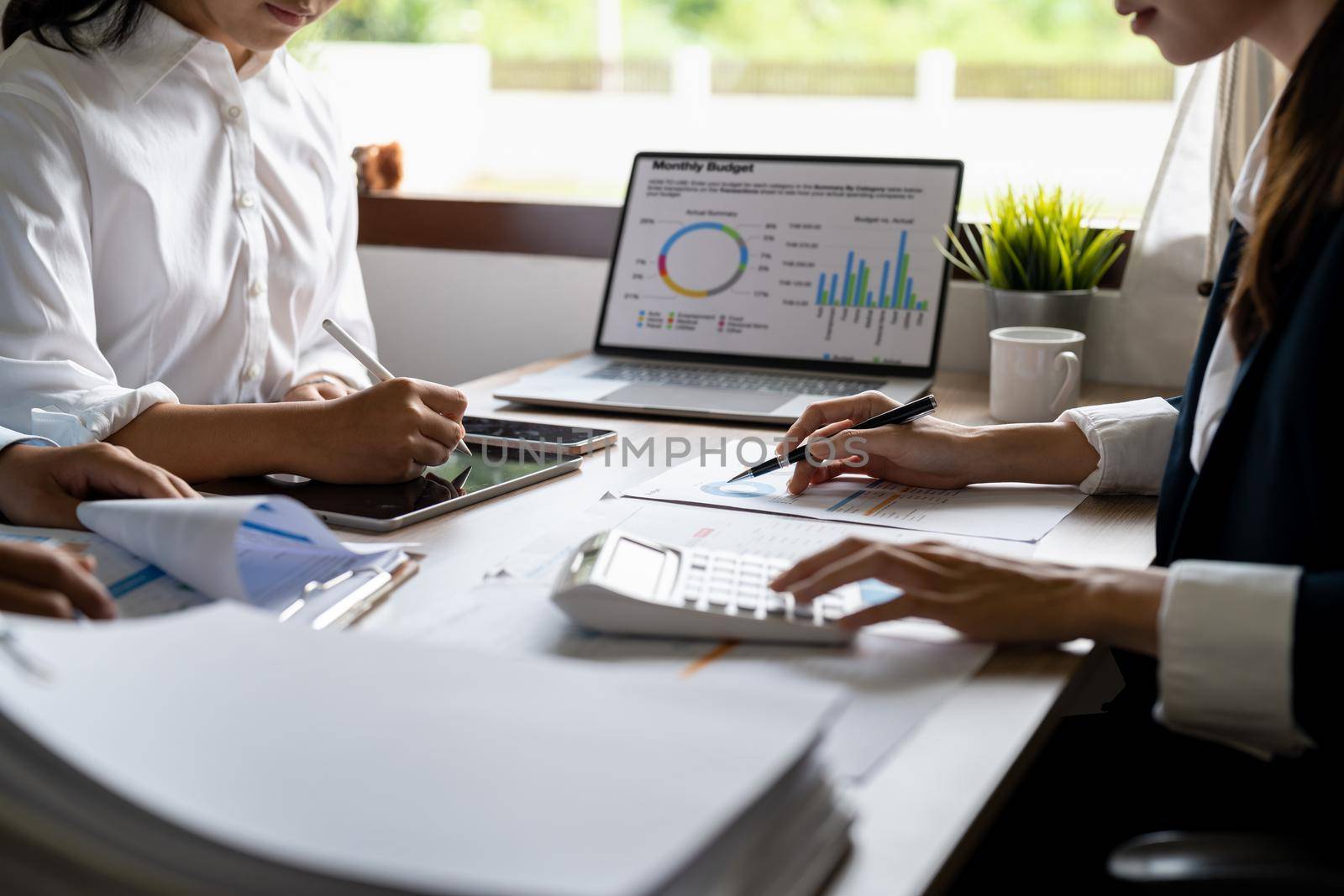 Asian business adviser meeting to analyze and discuss the situation on the financial report in the meeting room.Investment Consultant, Financial advisor and accounting concept.