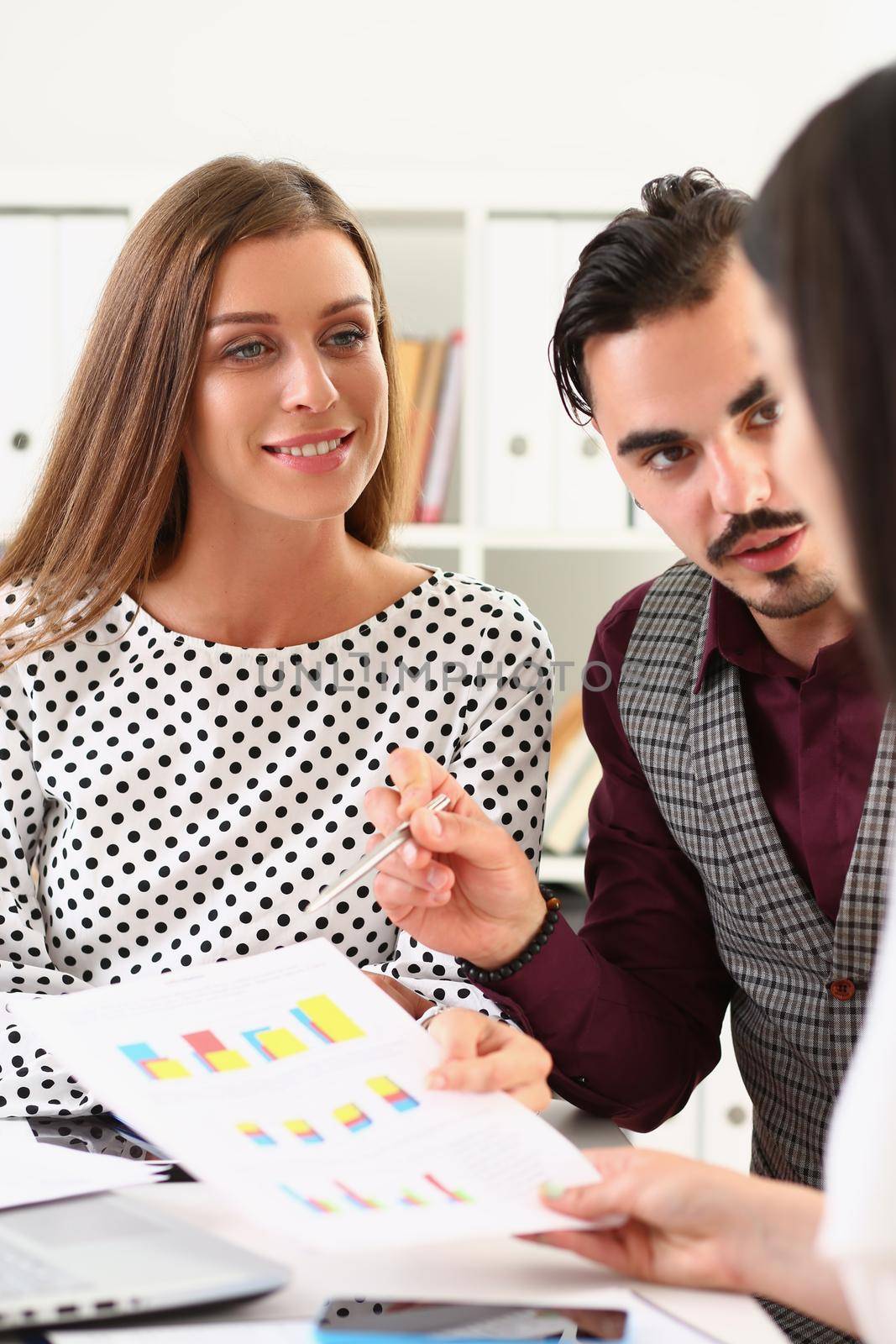 Business group of intelligent business colleagues discussing information and graphs on paper at table by kuprevich