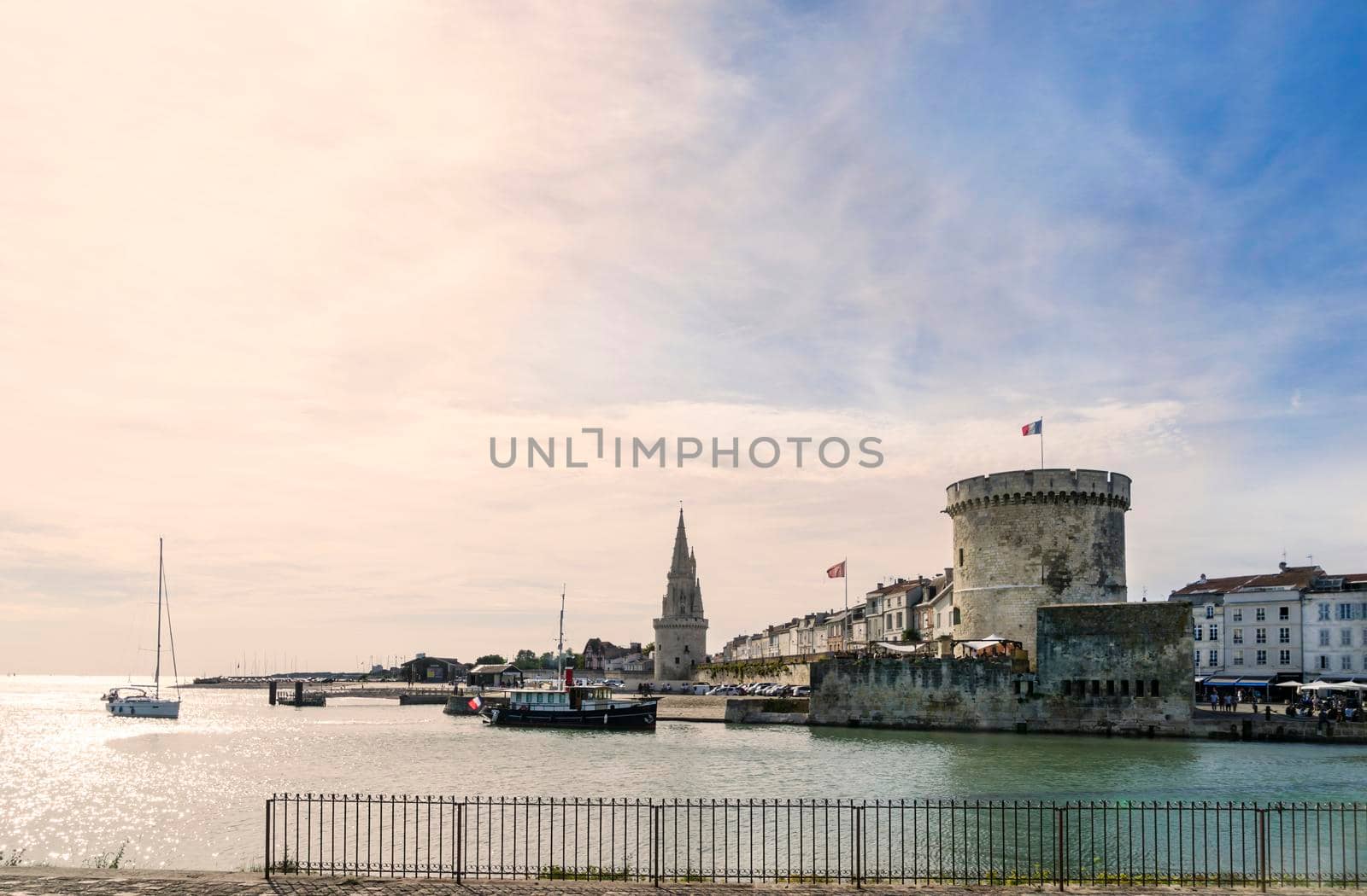 View of the entrance to the old port of the French city of La Rochelle with one of its towers at sunset. by csbphoto