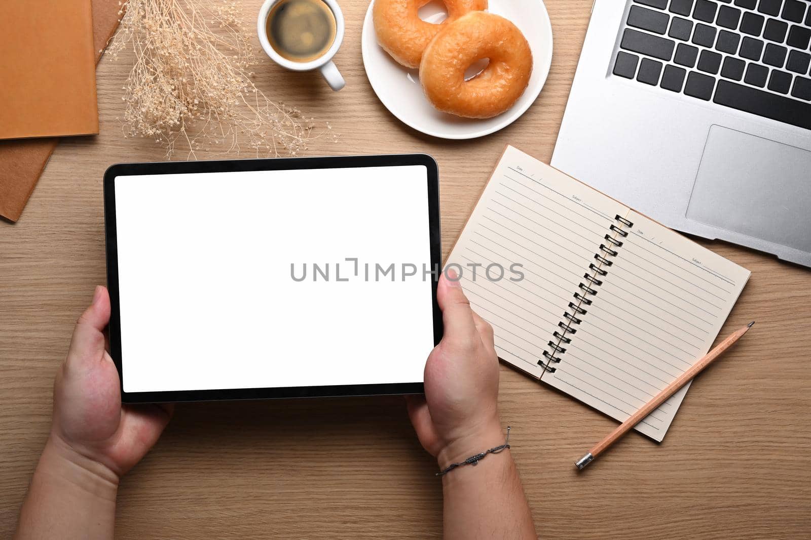 Overhead view man holding mock up digital table with white screen. by prathanchorruangsak