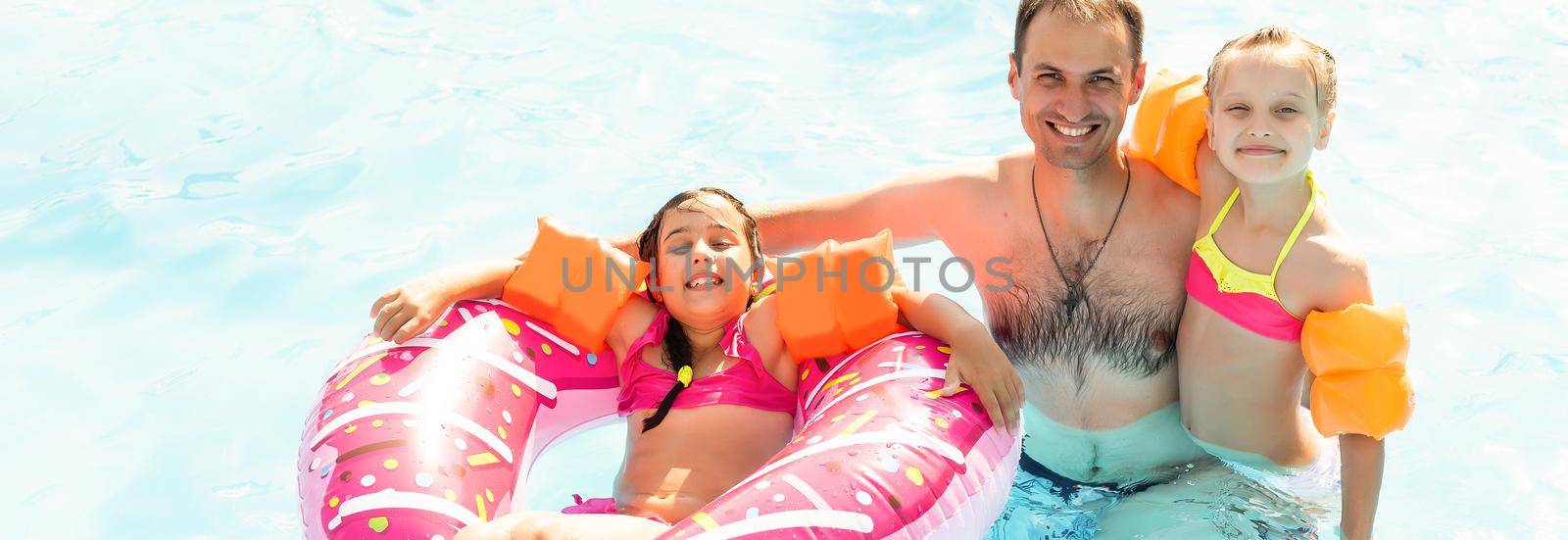 Children playing in pool. Two little girls having fun in the pool. Summer holidays and vacation concept.
