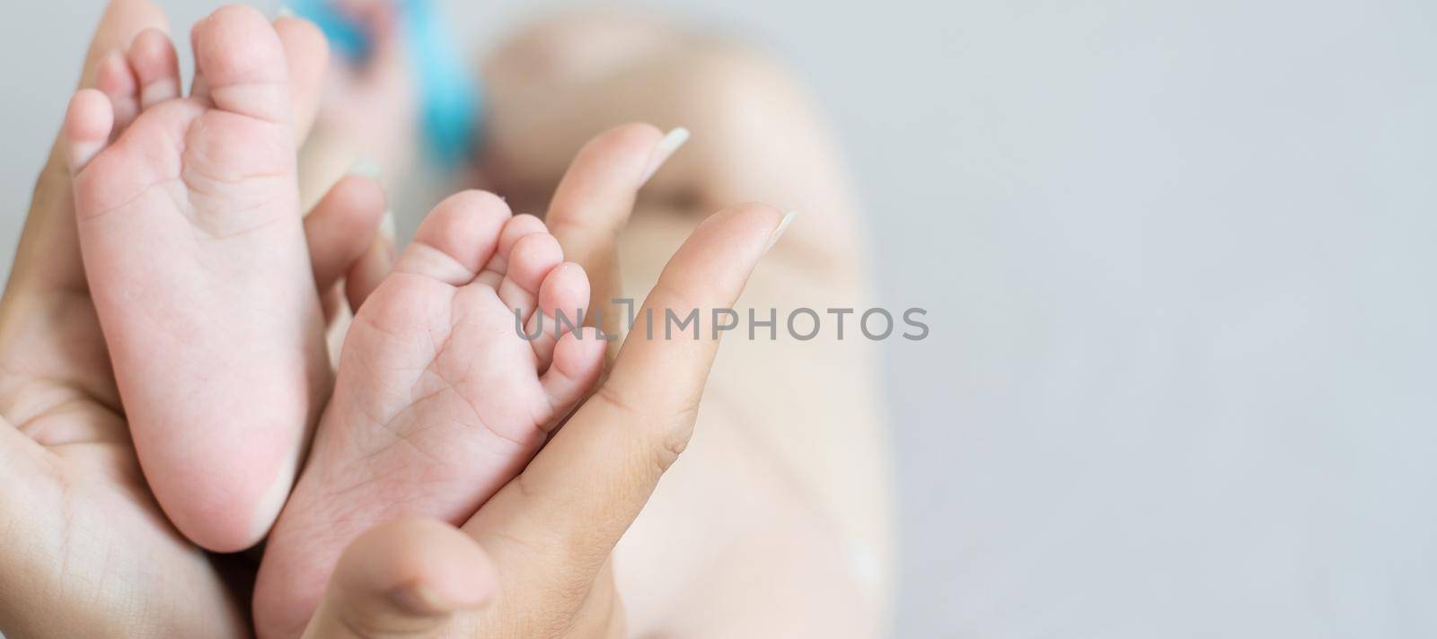 Parent holding in the hands feet of newborn baby.