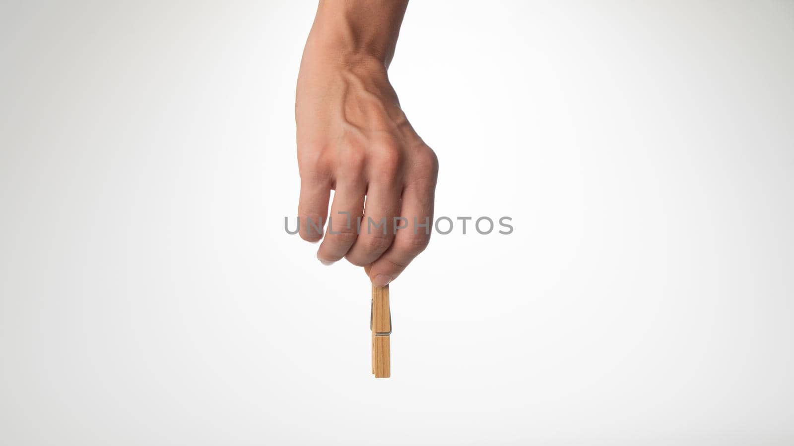 A woman's hand holds a wooden clothespin to secure the paper by voktybre