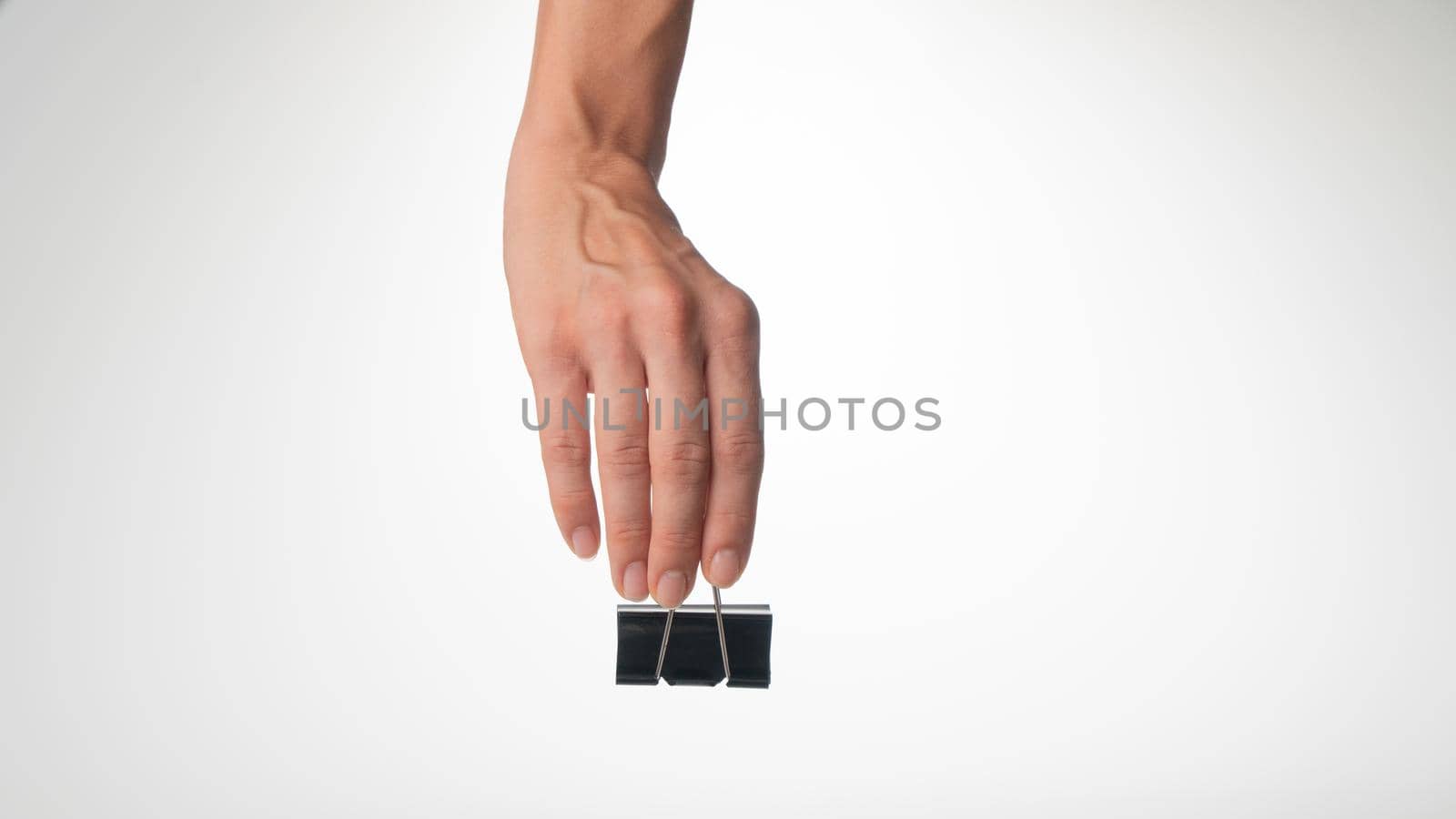 woman's hand on top holds a clip to clip paper space for text. High quality photo