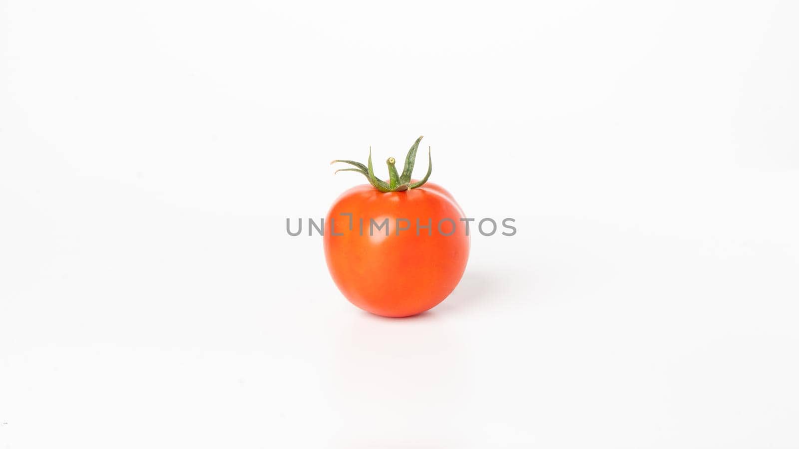 Tomato with a branch on a white background close-up vegetable by voktybre