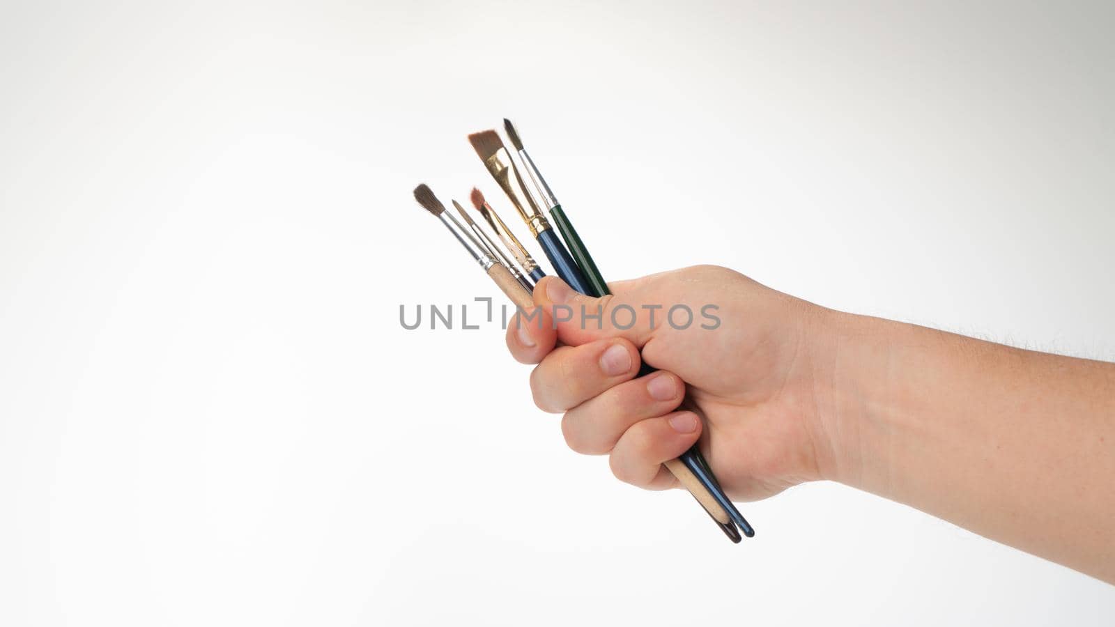 men's hand with a set of tassels for the artist on a white background. High quality photo