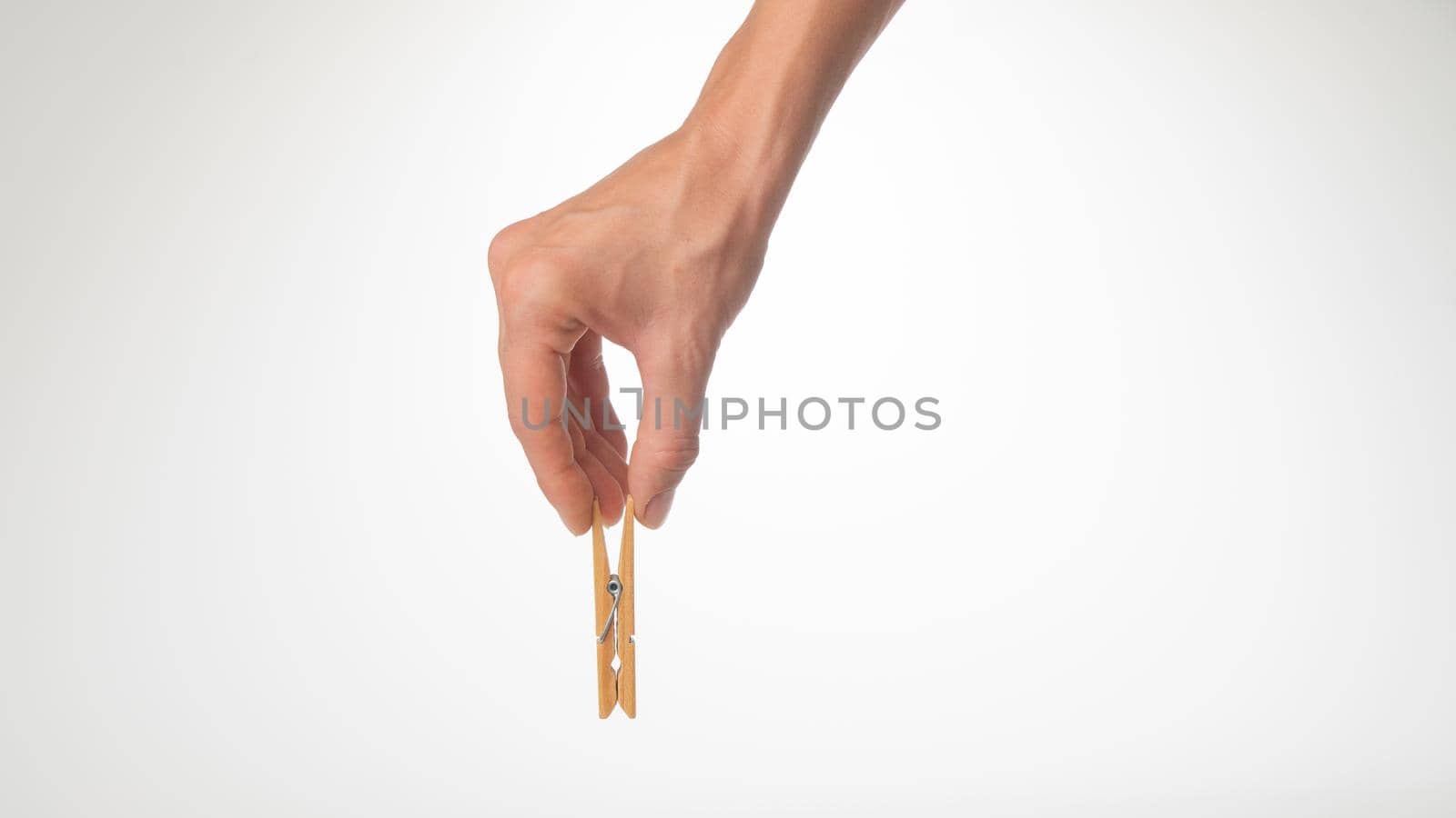 women's hand holds a wooden gesture clothespin place for writing by voktybre