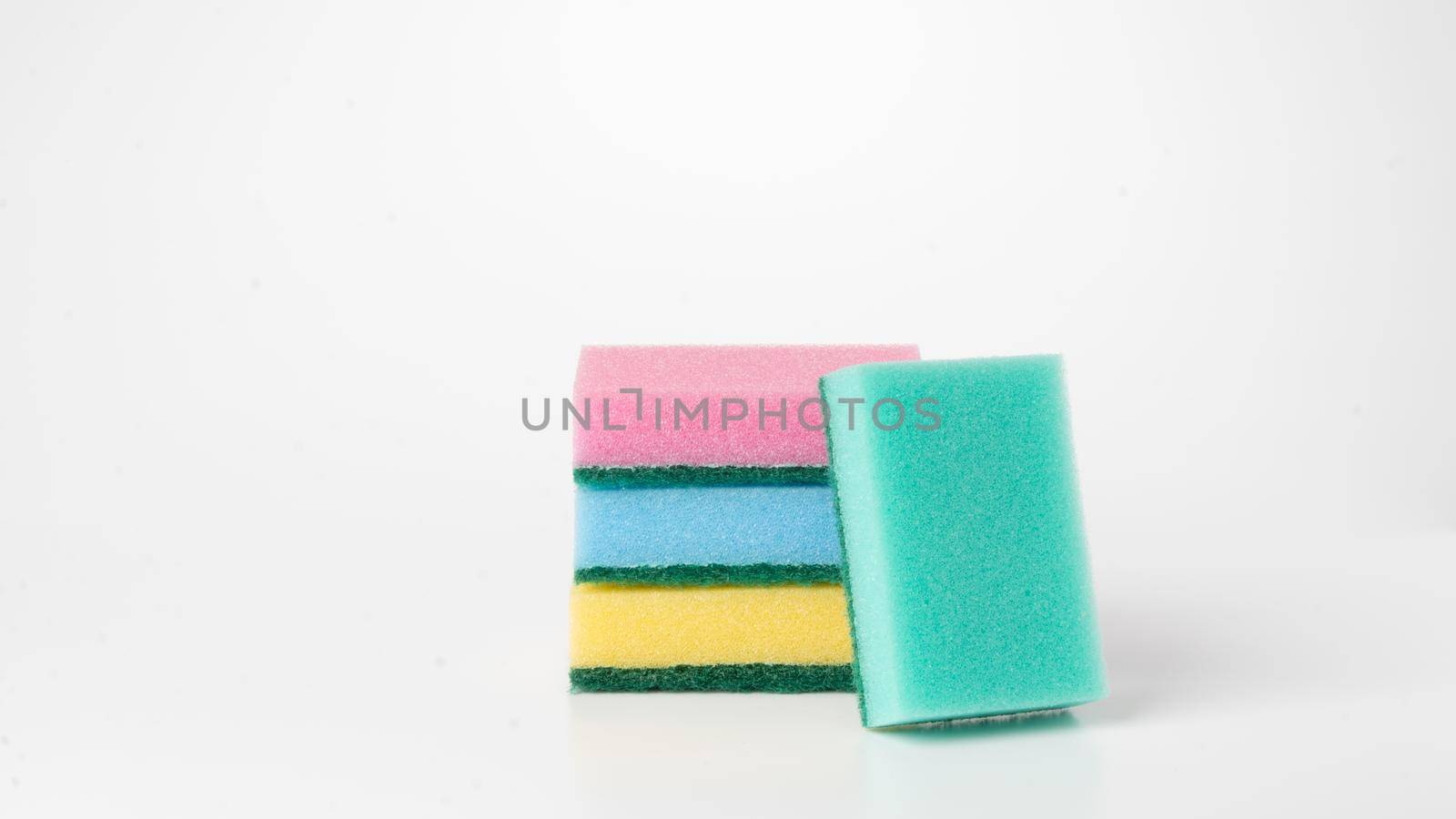 Sponges of different colors are stacked on a white background by voktybre