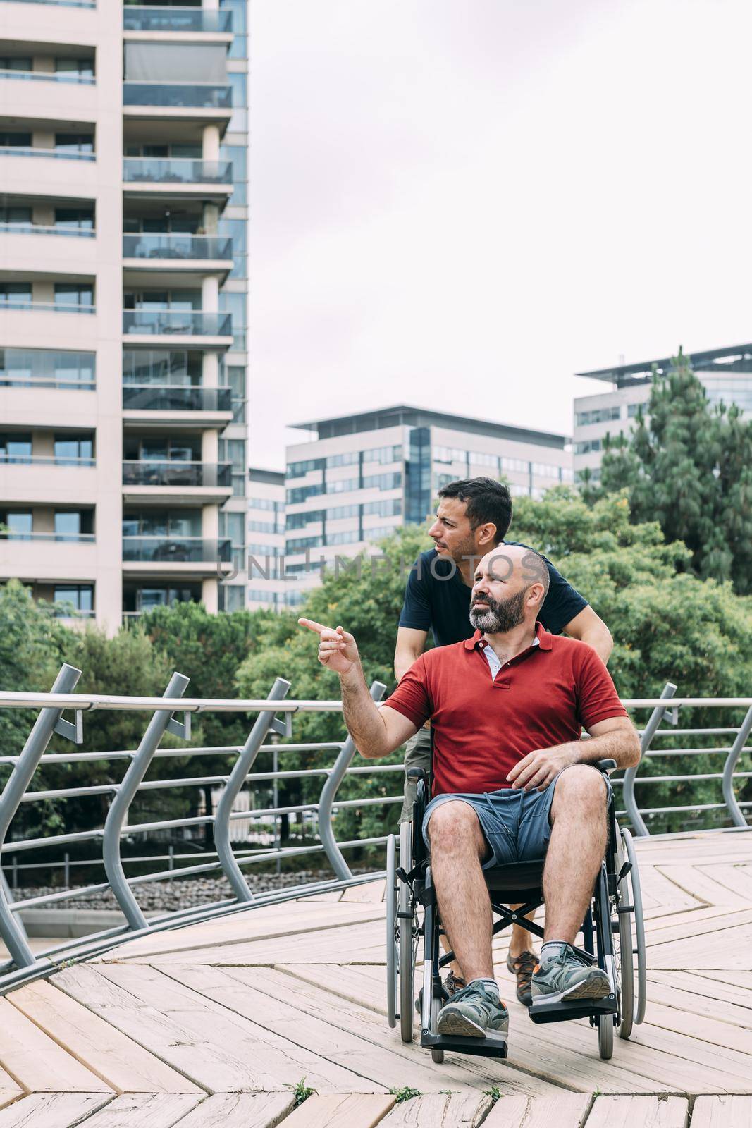 man in wheelchair conversing with his friend by raulmelldo