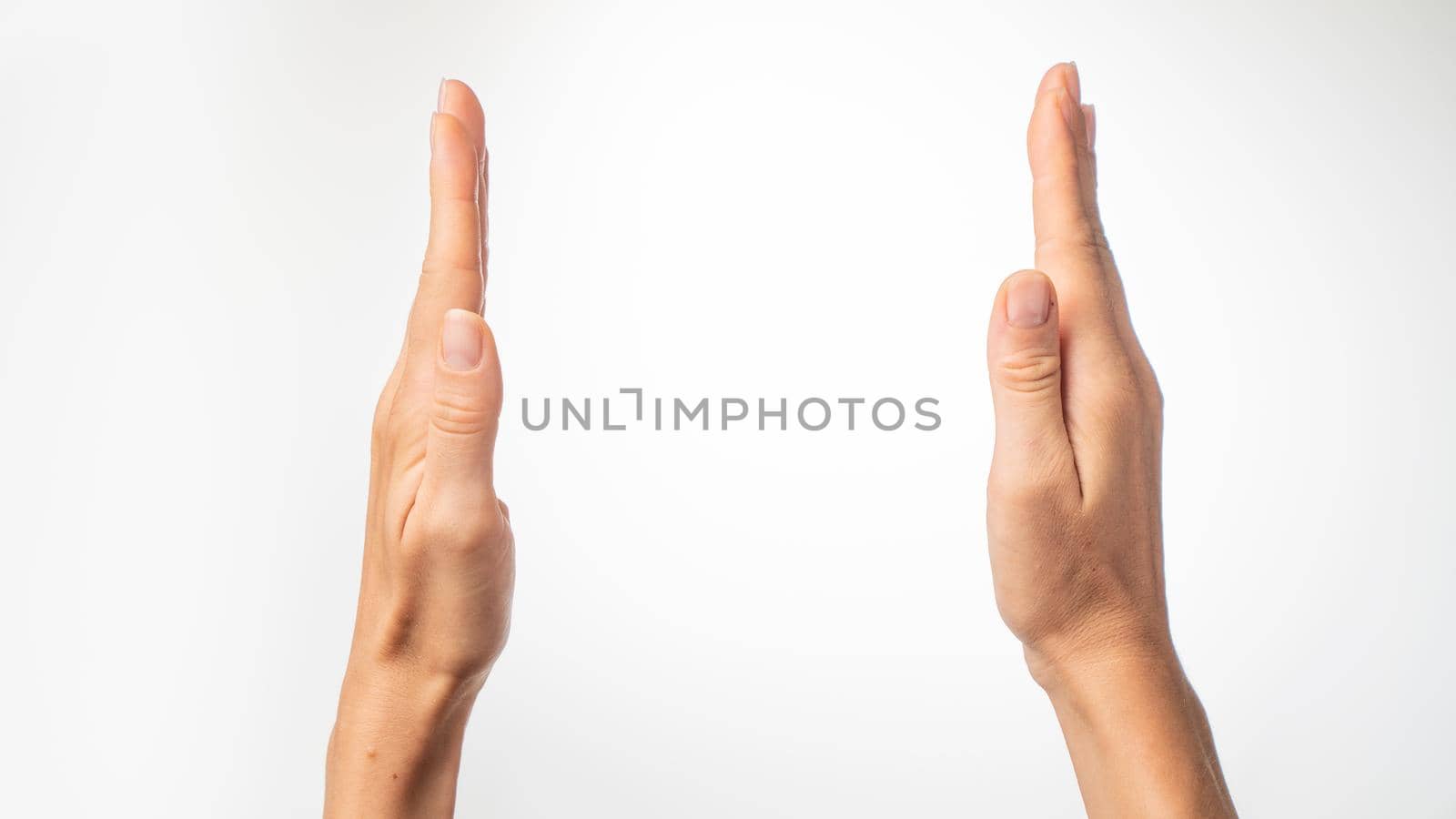 Women's hands show the distance with their palms on a white background. High quality photo