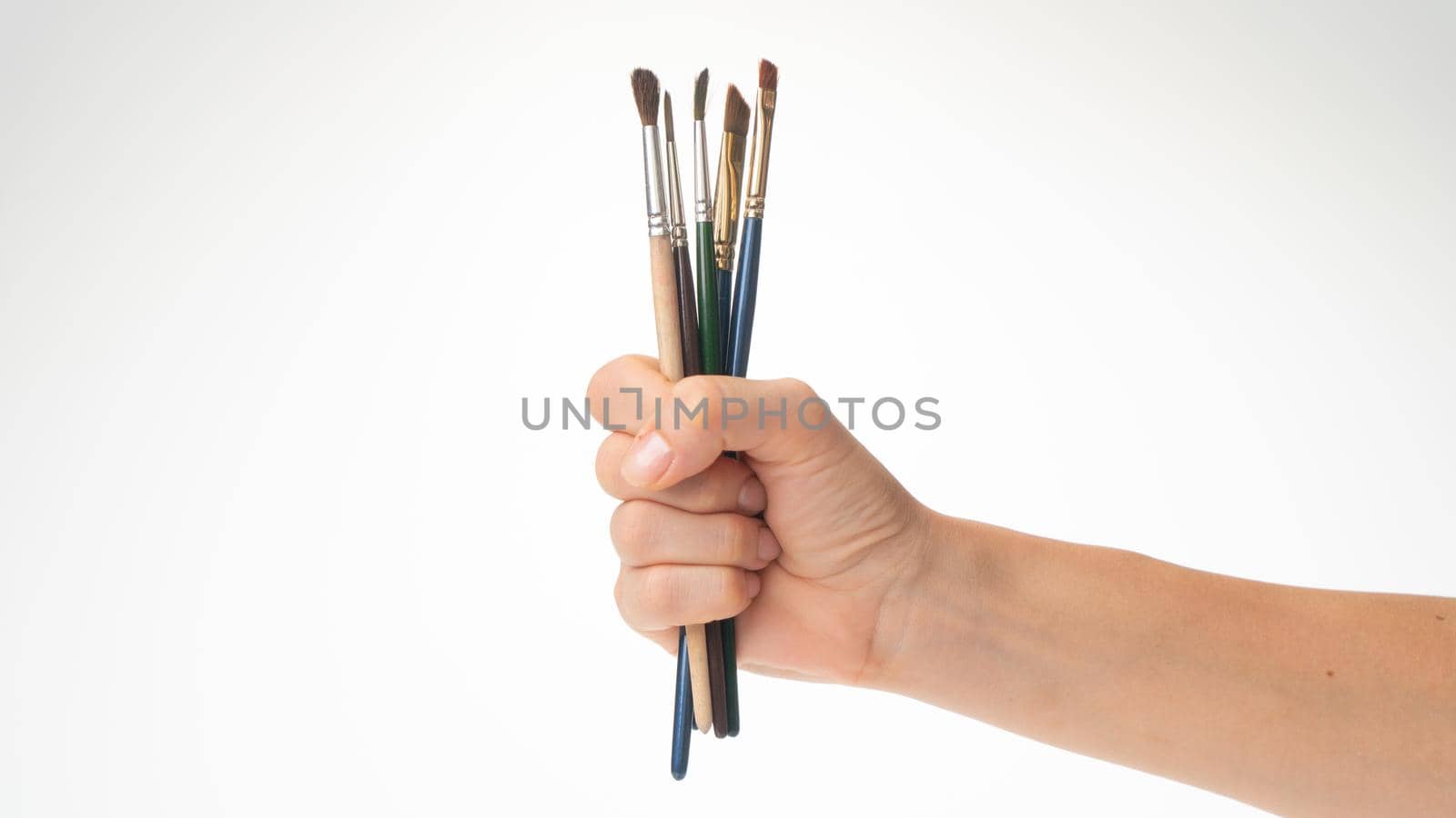 Woman's hand with a set of tassels for the artist on a white background by voktybre