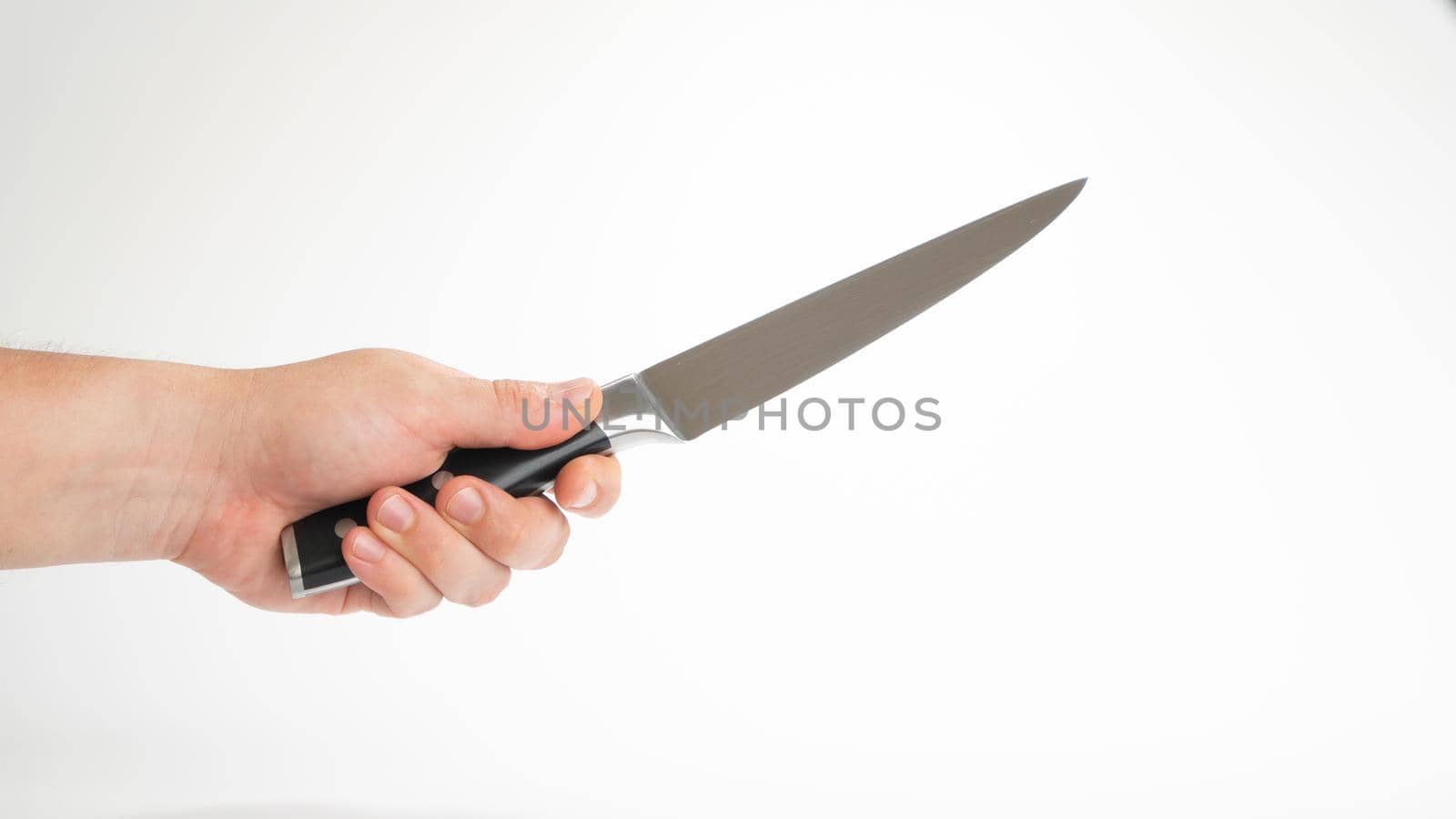 Kitchen knife in a man's hand, holds diagonally on a white background. High quality photo