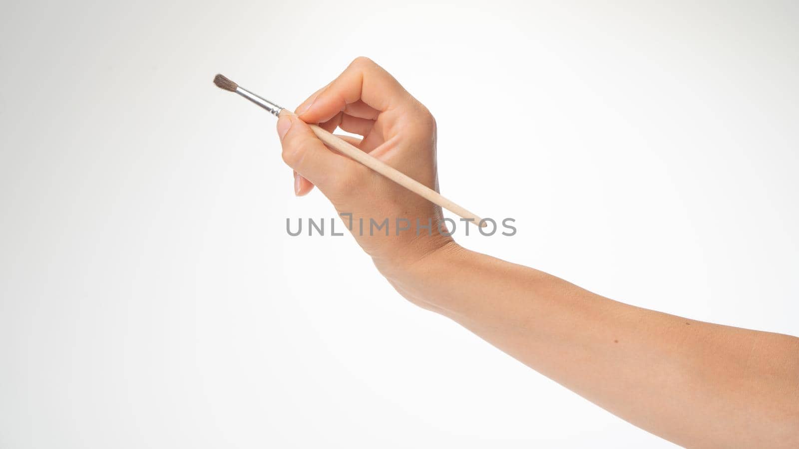 Drawing brush in a woman's right hand, gesture to draw on a white background by voktybre