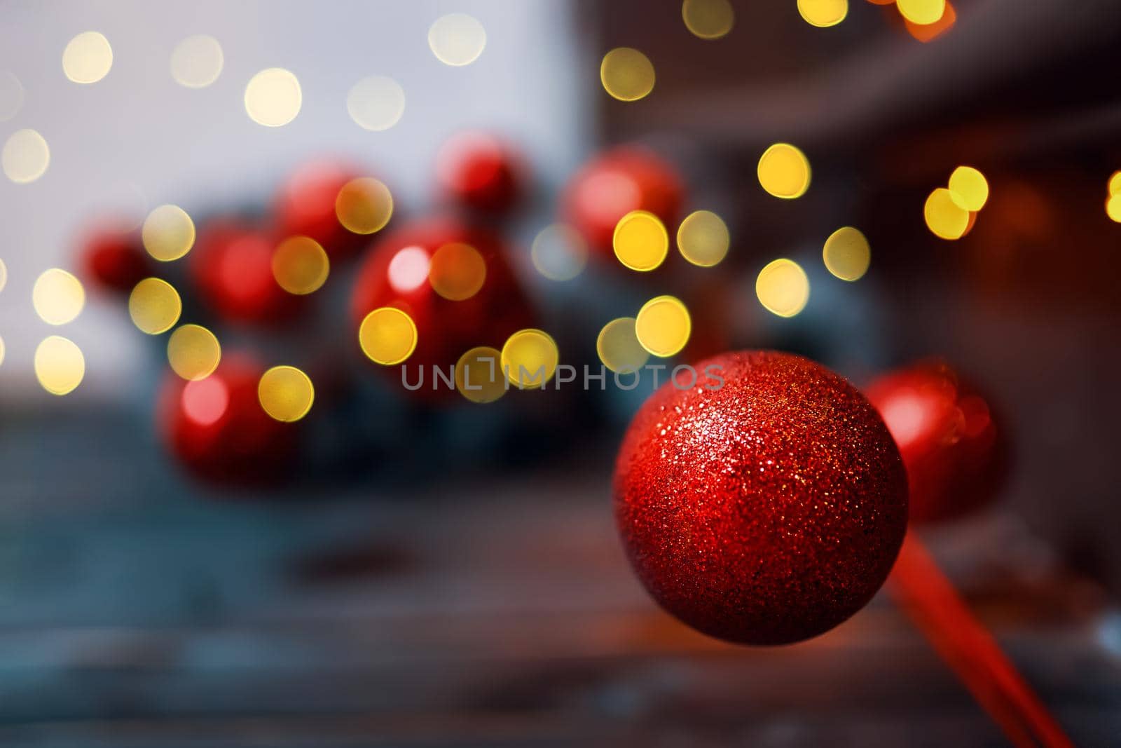 Christmas red glitter ball on blurred background. Holiday ornaments. Card with New Year decoration and copy space for congratulations.
