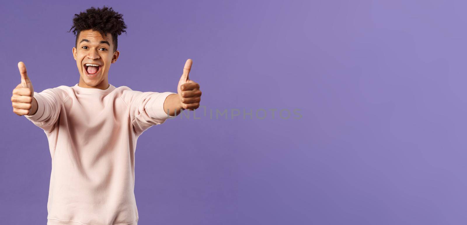 Portrait of satisfied young happy man think event was super cool, recommend use company service, assure in best quality, like and approve awesome product, standing purple background.