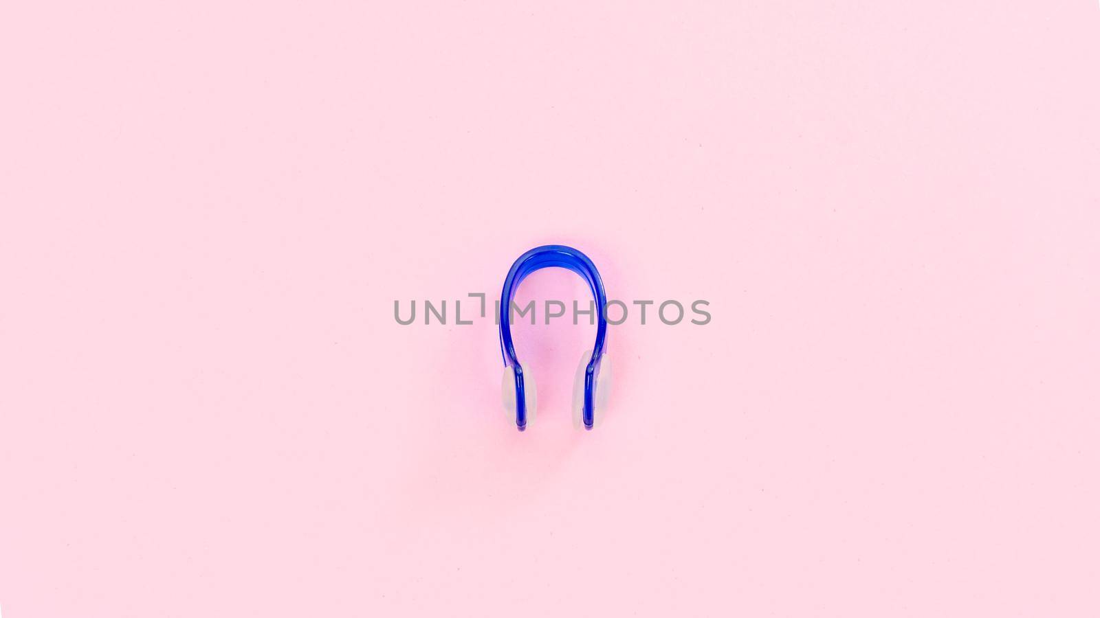 Purple swimming nose clip on pink background. High quality photo