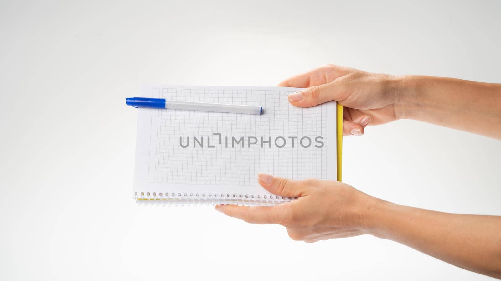 Women's hands hold the notebook with both hands, the gesture passes the notebook with a pen. High quality photo