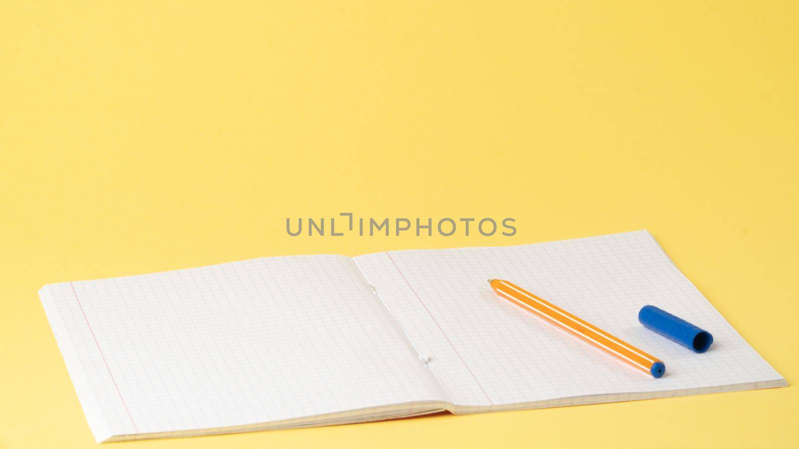 Notebook and pen on the table on a yellow background, space for text, learning by voktybre
