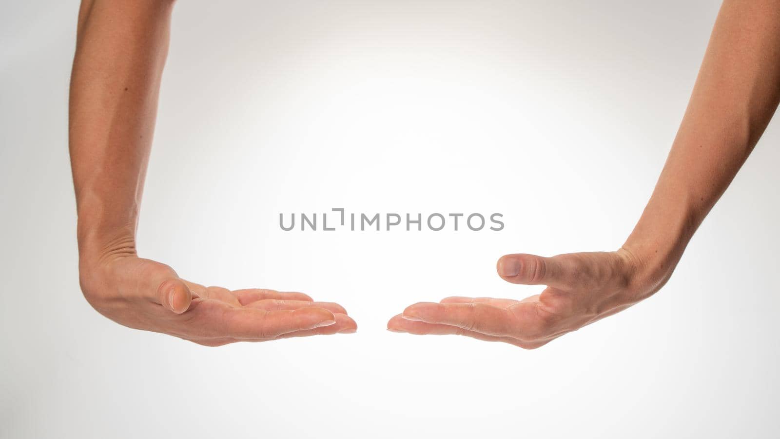 Women's hands insulated hold a large object on a white background. High quality photo