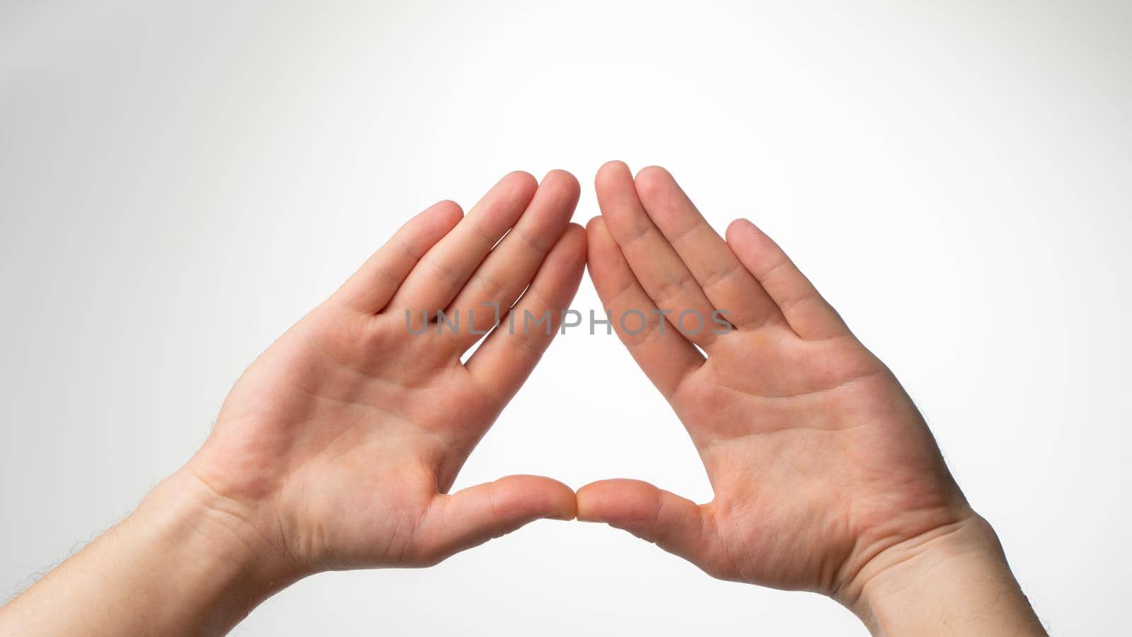 The man's palms are folded in a triangle on a white background by voktybre