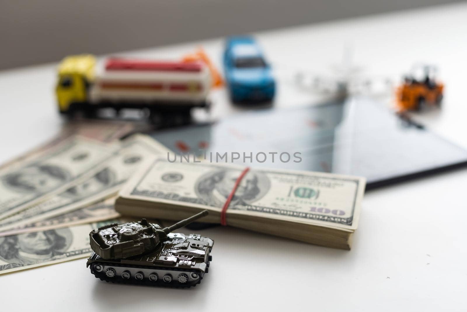 a toy tank, dollars and a tablet by Andelov13