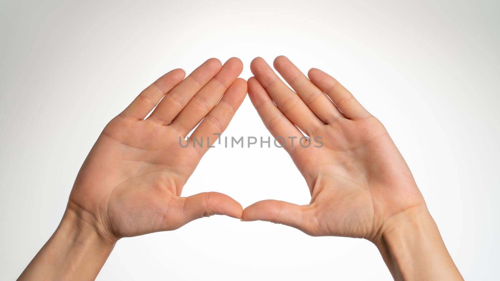 a woman's palms palms are folded in a triangle on a white background. High quality photo