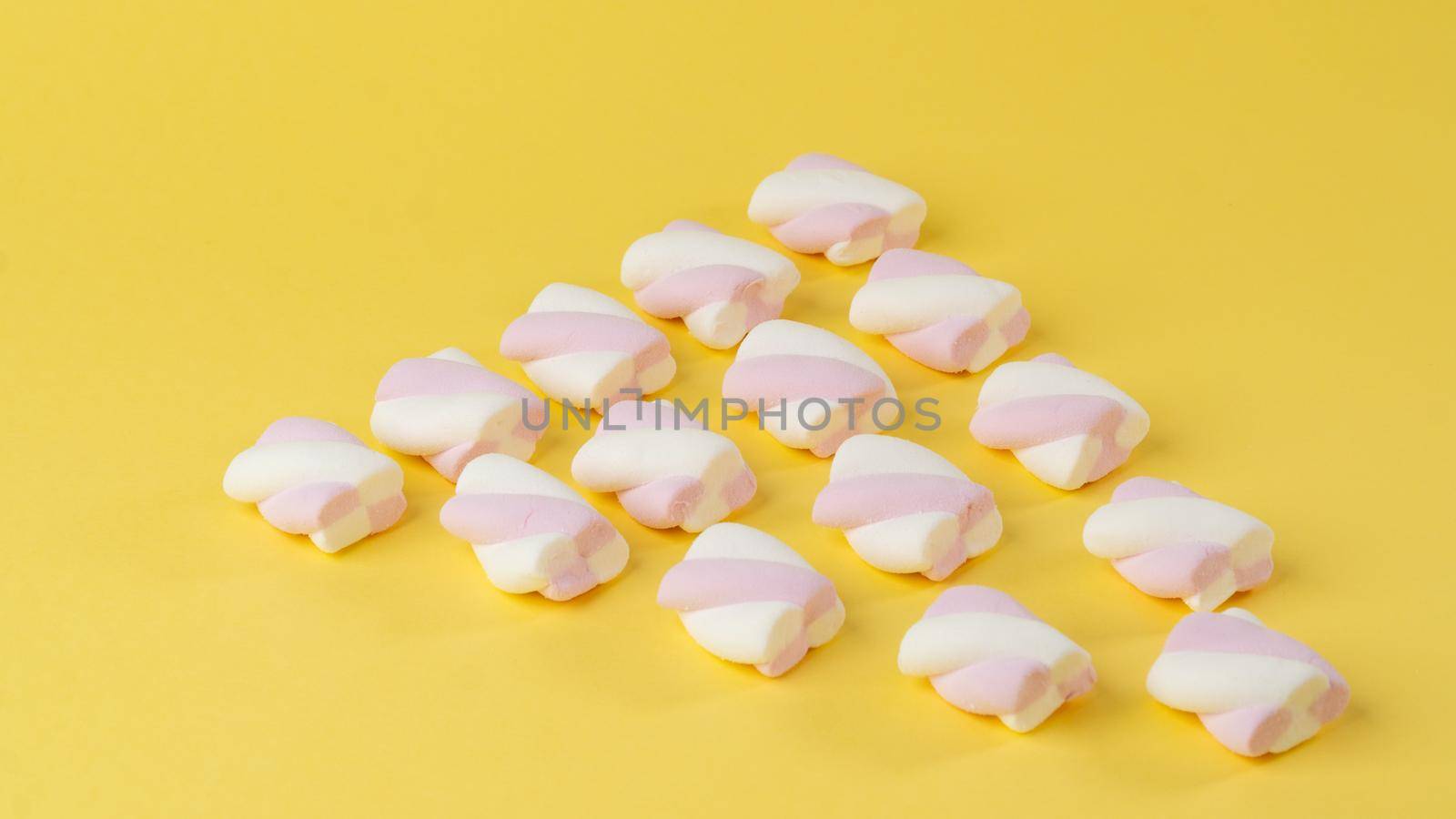 Background of marshmallow pigtails on a yellow background. High quality photo