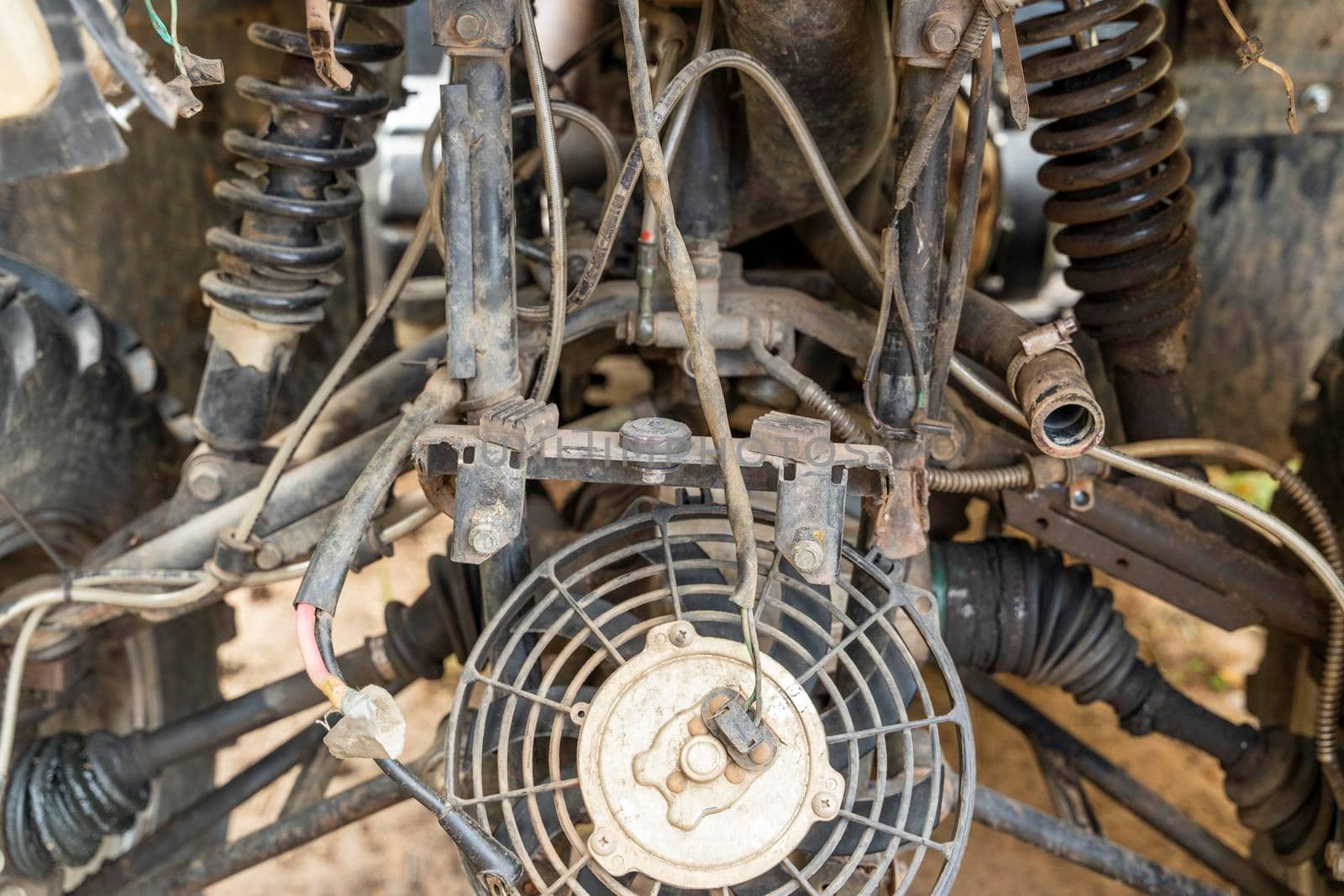 the front part of a broken and disassembled ATV in need of repair. cooling radiator, cooling fan
