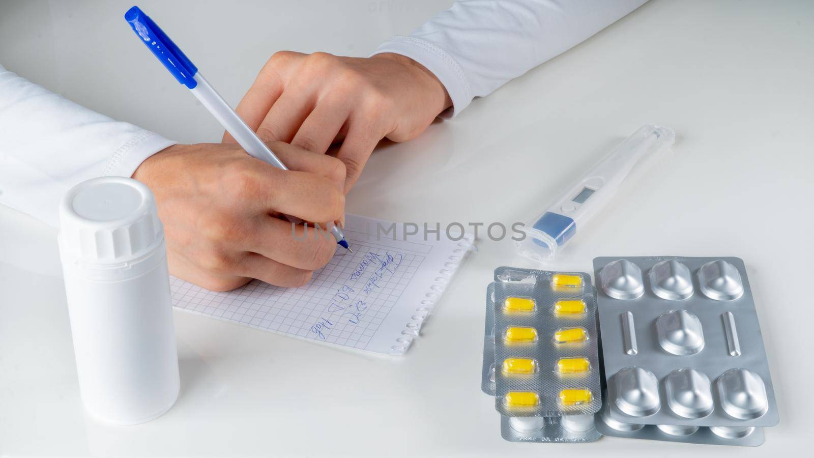 The doctor writes a medical prescription for the disease against the background of drugs, tablets. High quality photo