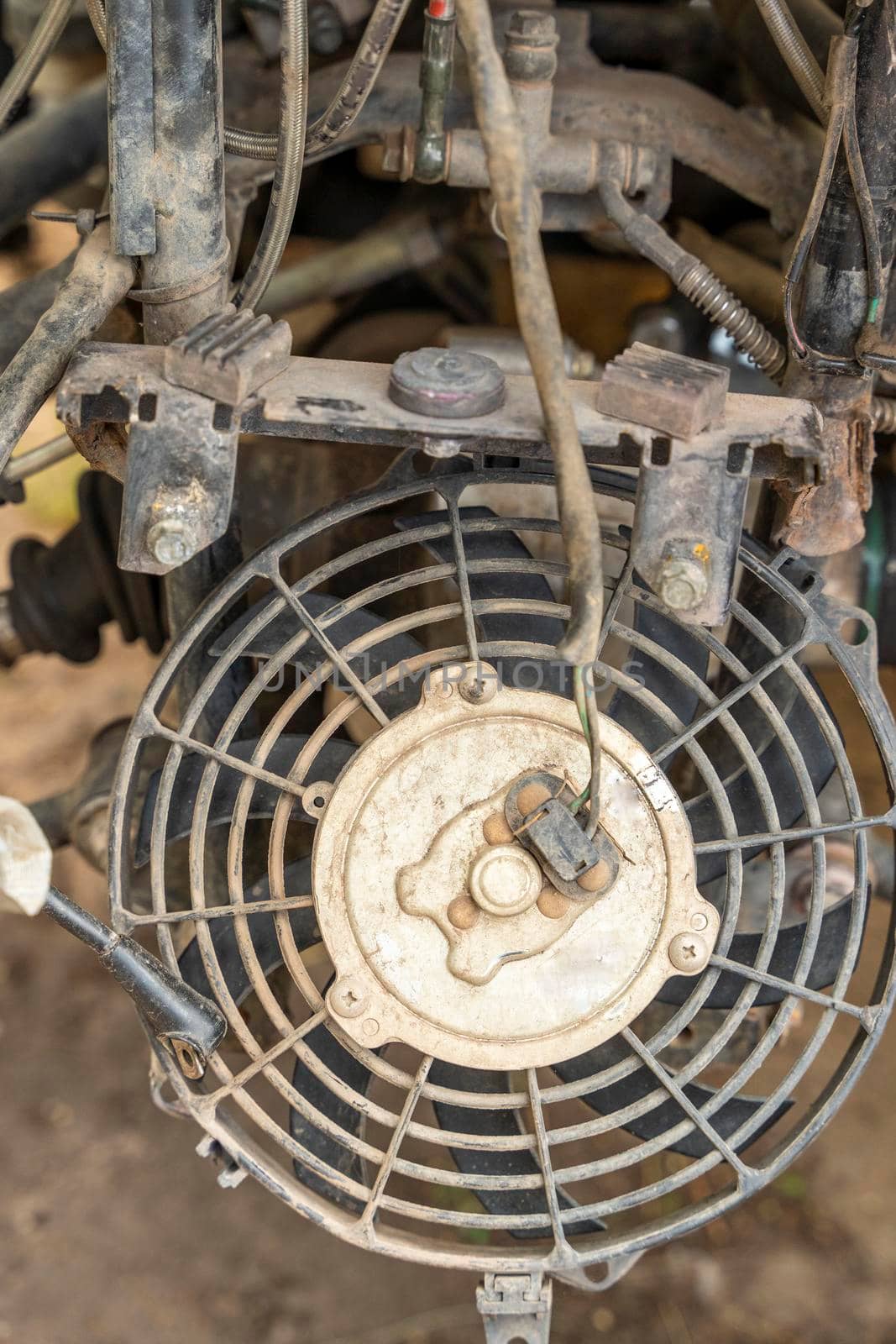 the front part of a broken and disassembled ATV in need of repair. cooling radiator, cooling fan. vertical photo