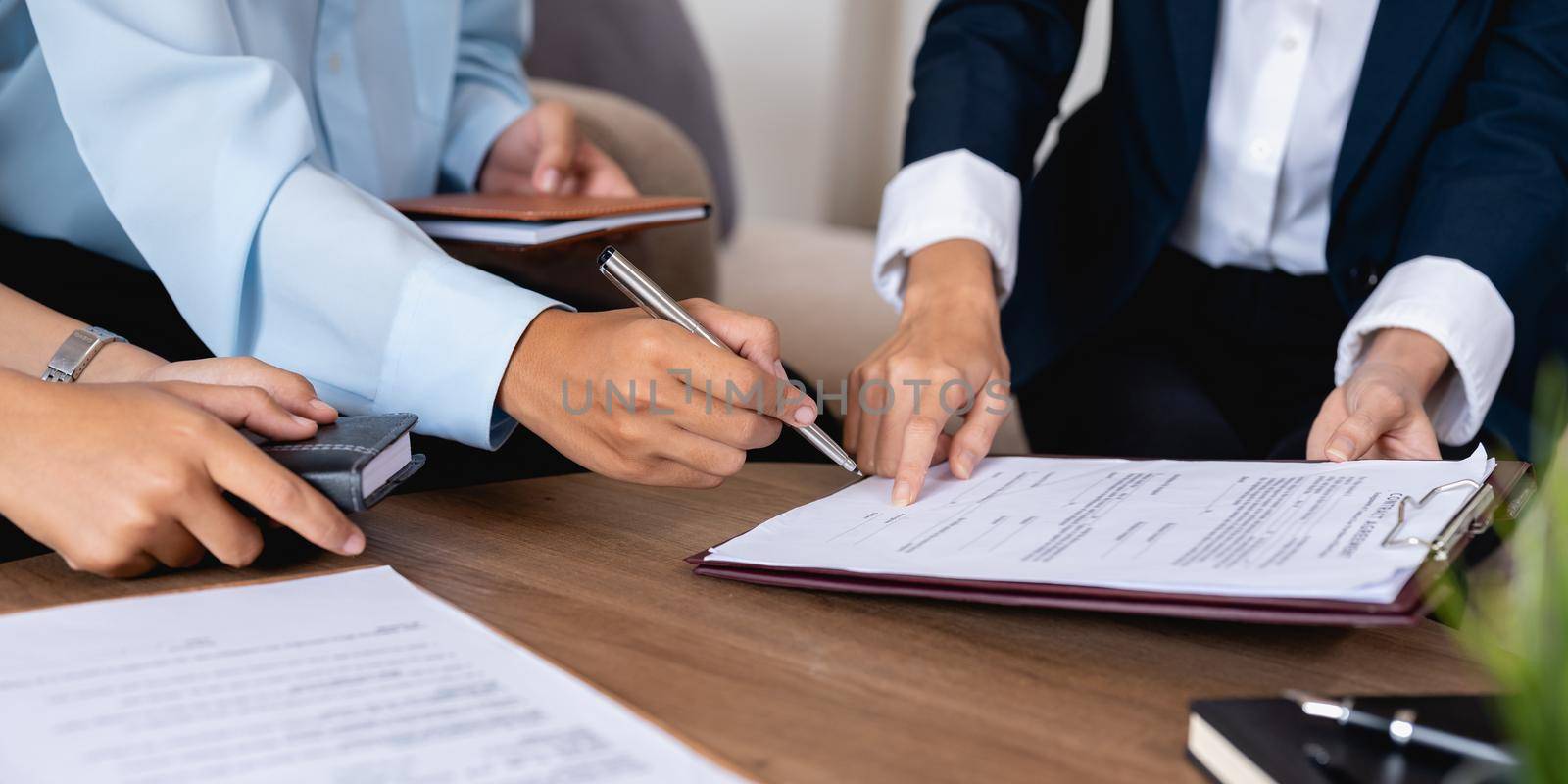 Couple clients signing paper contract with professional broker or realtor, after discussing agreement details.