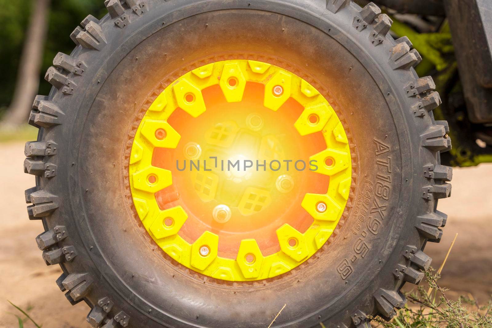 Close-up of the ATV wheel on sandy ground. Dirty wheel of a four-wheel drive all-terrain vehicle. The concept of travel and adventure