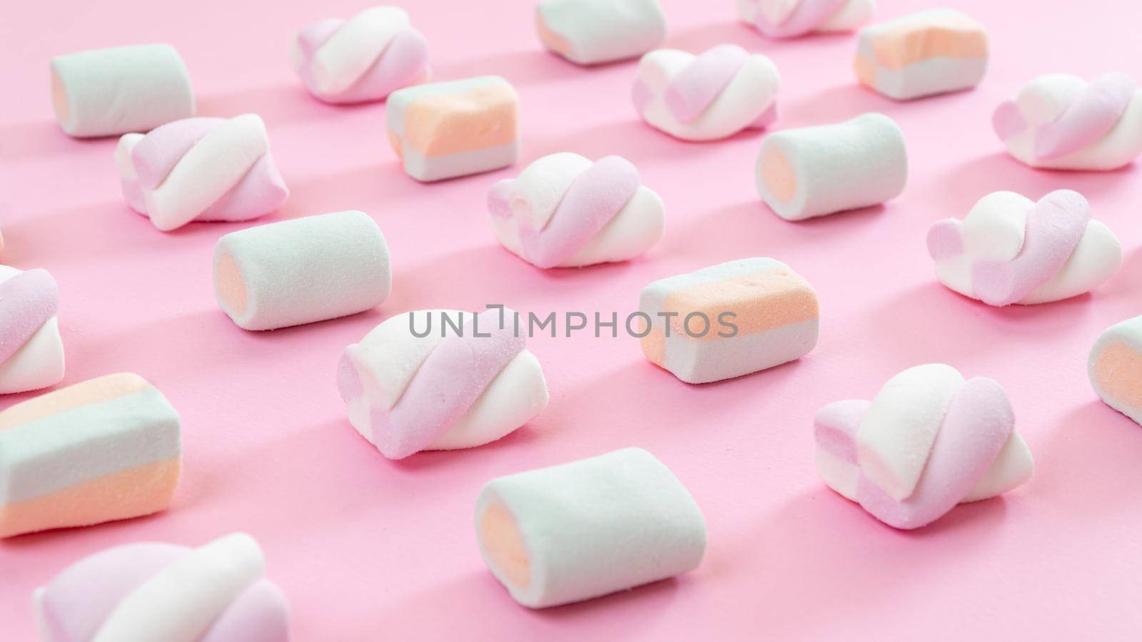 Marshmallow lined up diagonally - pink background with sweets. High quality photo